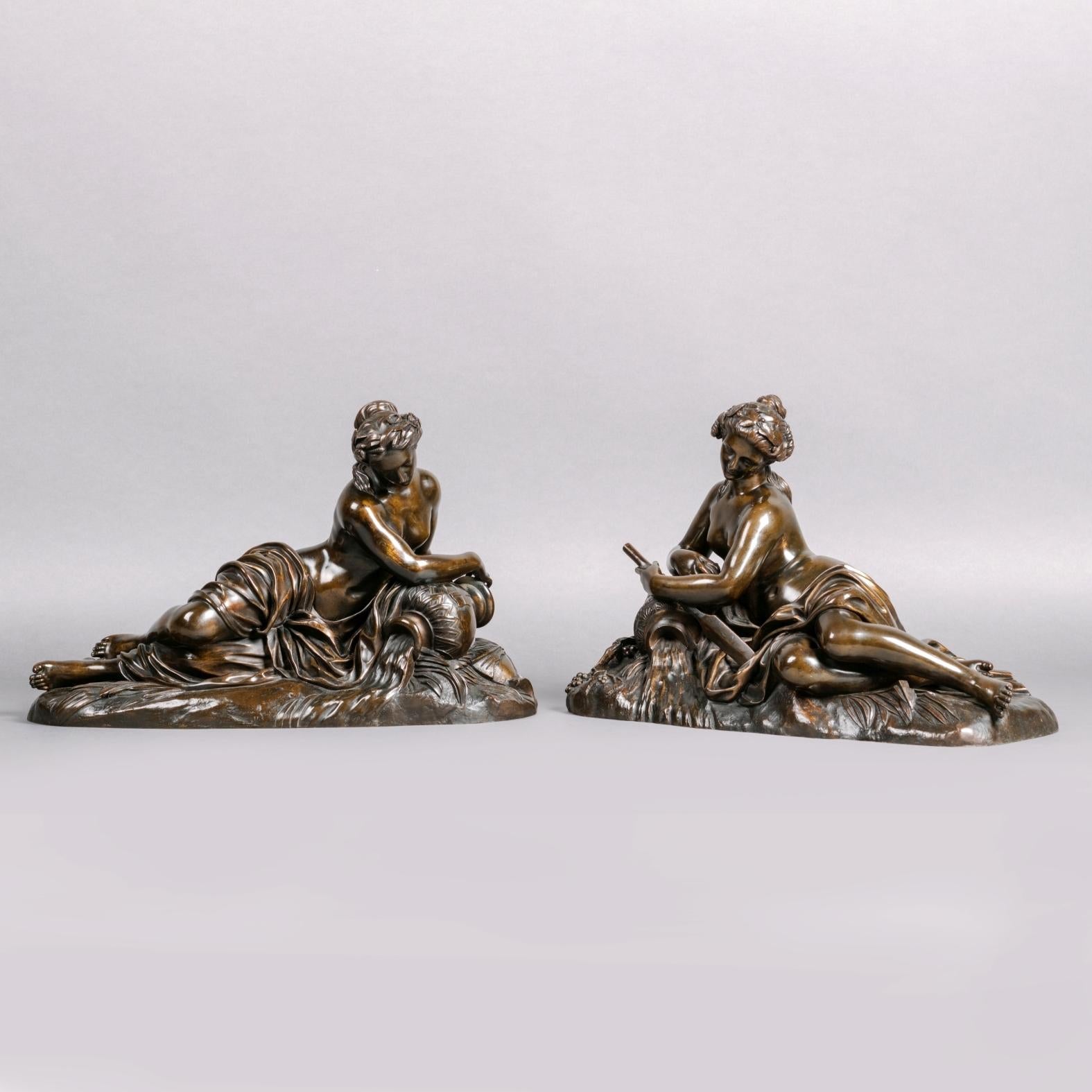 Paire de figures en bronze patiné représentant des nymphes de rivière, d'après Jean Goujon. 

Ces charmantes figures sont inspirées des nymphes de la monumentale 