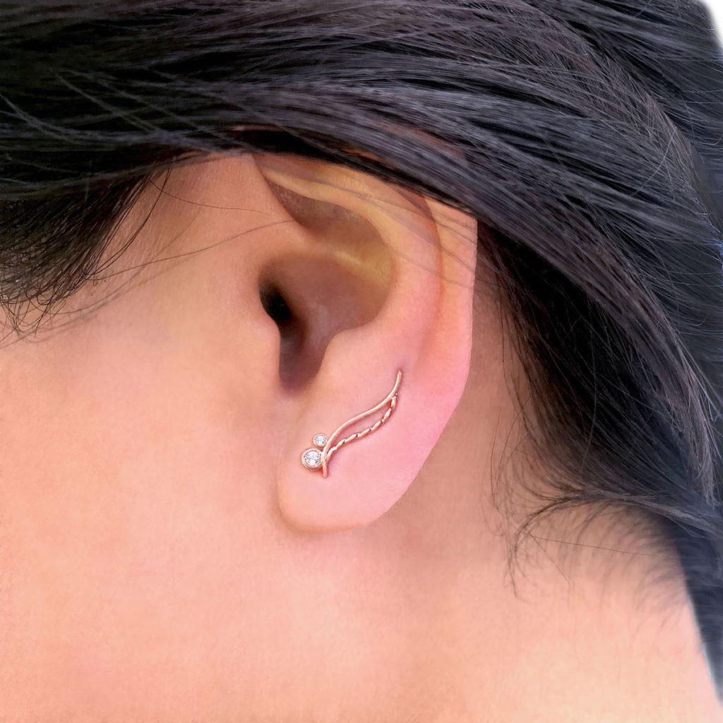 River Rose diamond double wave ear climber featuring JeweLyrie signature infinity twist forged in flowing wave double up with high polish square line, with bezel set 1.25mm and 2mm diamond perch at the tip. A contour back wire clip secure the