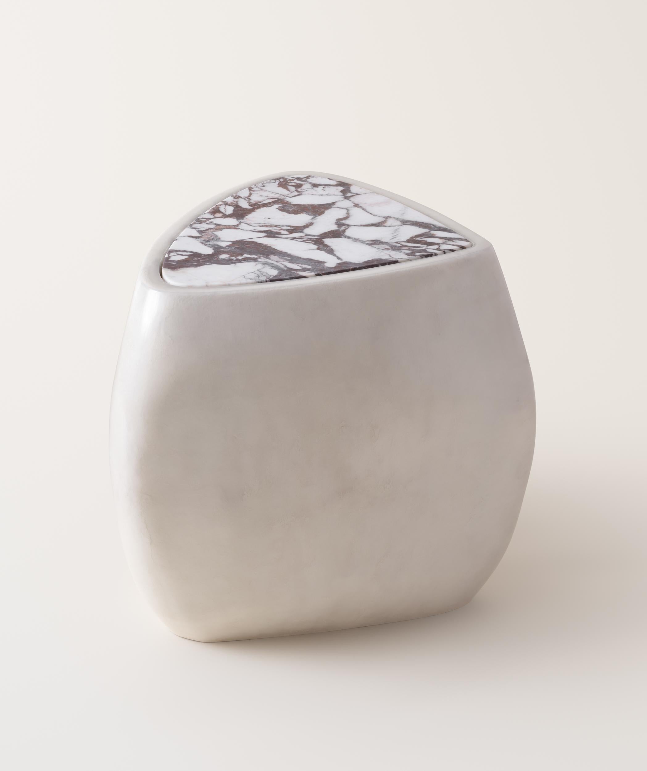 Inspired by stones shaped and polished by ever-evolving bodies of water, the River Side Table presents a sculptural, asymmetrical form made up of soft curves and lines. The table is expertly made by hand-layering fiberglass and gel coat over several