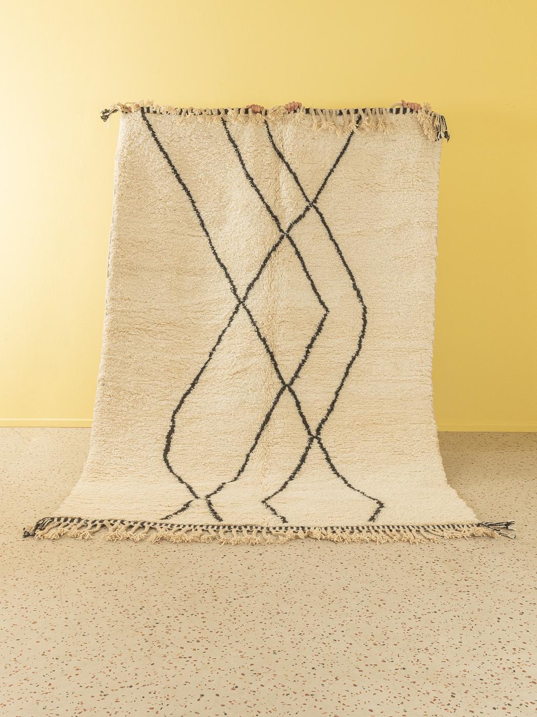 Rivers ist ein moderner Teppich aus 100 % Wolle - dick und weich, angenehm zu tragen. Unsere Berberteppiche werden von Amazigh-Frauen im Atlasgebirge handgewebt und handgeknüpft. Diese Gemeinschaften stellen schon seit Tausenden von Jahren Teppiche