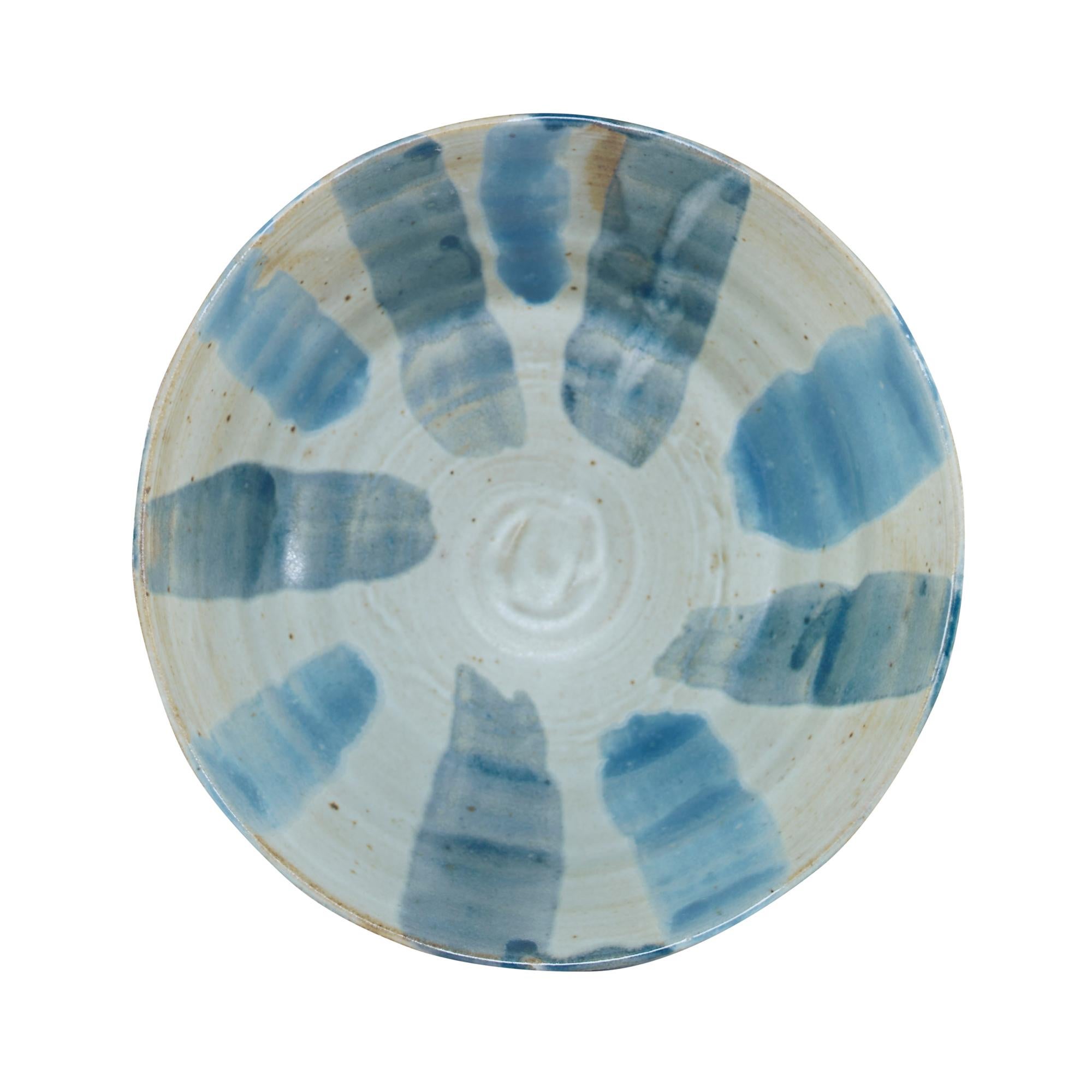 Inspired by Japanese raku, this handmade stoneware bowl features decorative blue stripes painted in contrast to a creamy background. Due to the handmade nature of this product, slight variation in color, pattern, shape and/or size is to be