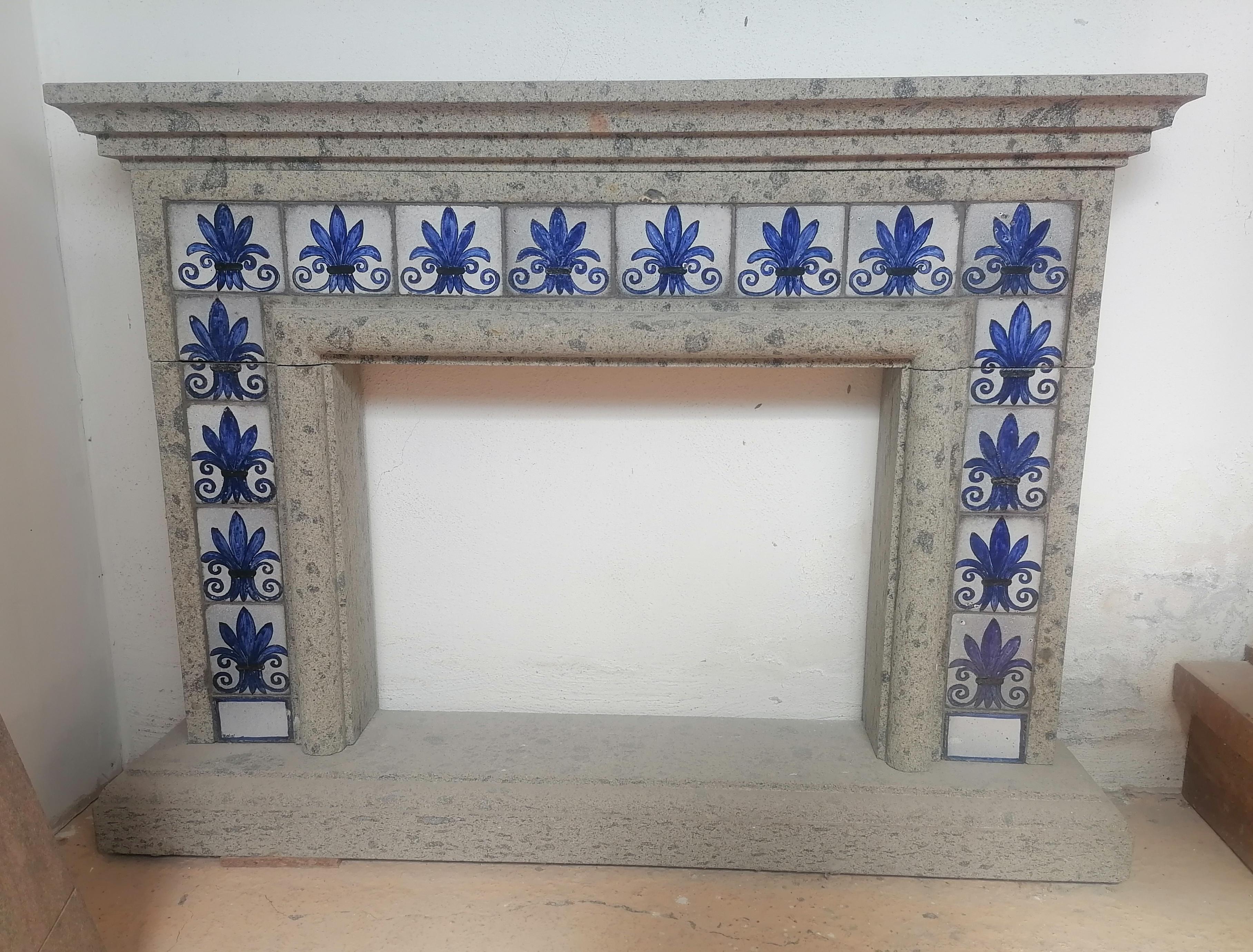 Cheminée très originale en peperino gris sculpté à la main, les décorations sont toujours réalisées dans le même matériau, mais elles ont été émaillées et décorées avec de l'émail. Le peperino permet cela car, étant une pierre volcanique, il peut