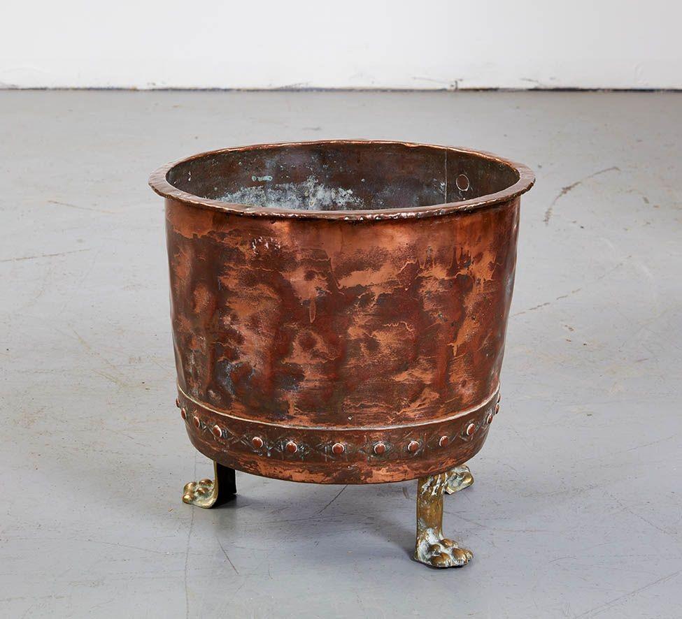 Good English 19th century hand riveted copper pot with flared lip, now on brass paw feet. Perfect for firewood or as planter.