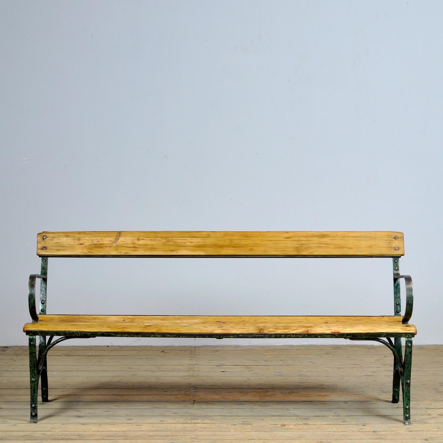 Park bench from the 1920s. With a heavily riveted iron base with traces of paint. Very nice vintage condition.