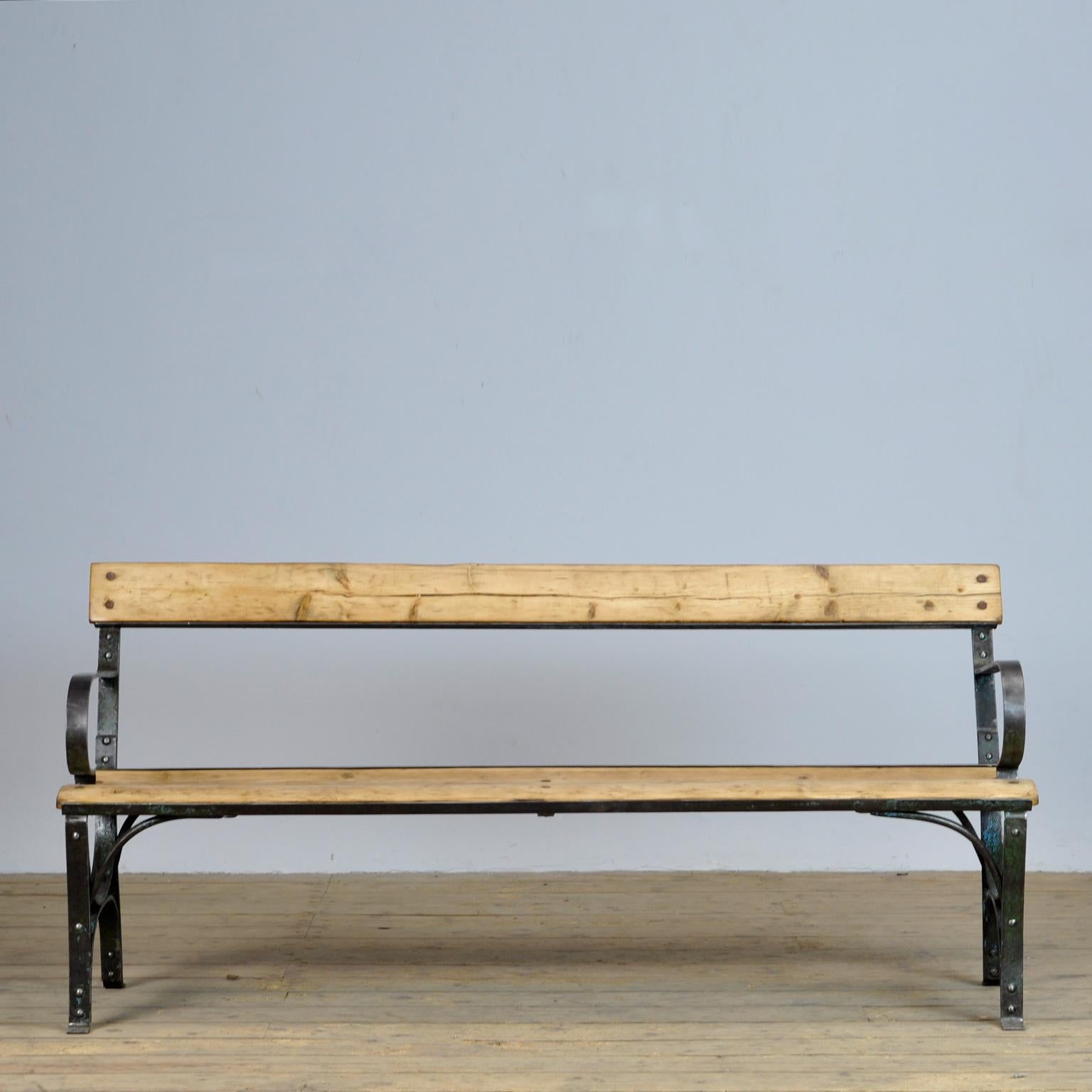 Park bench from the 1930s. With a heavily riveted iron base with traces of paint. Very nice vintage condition.