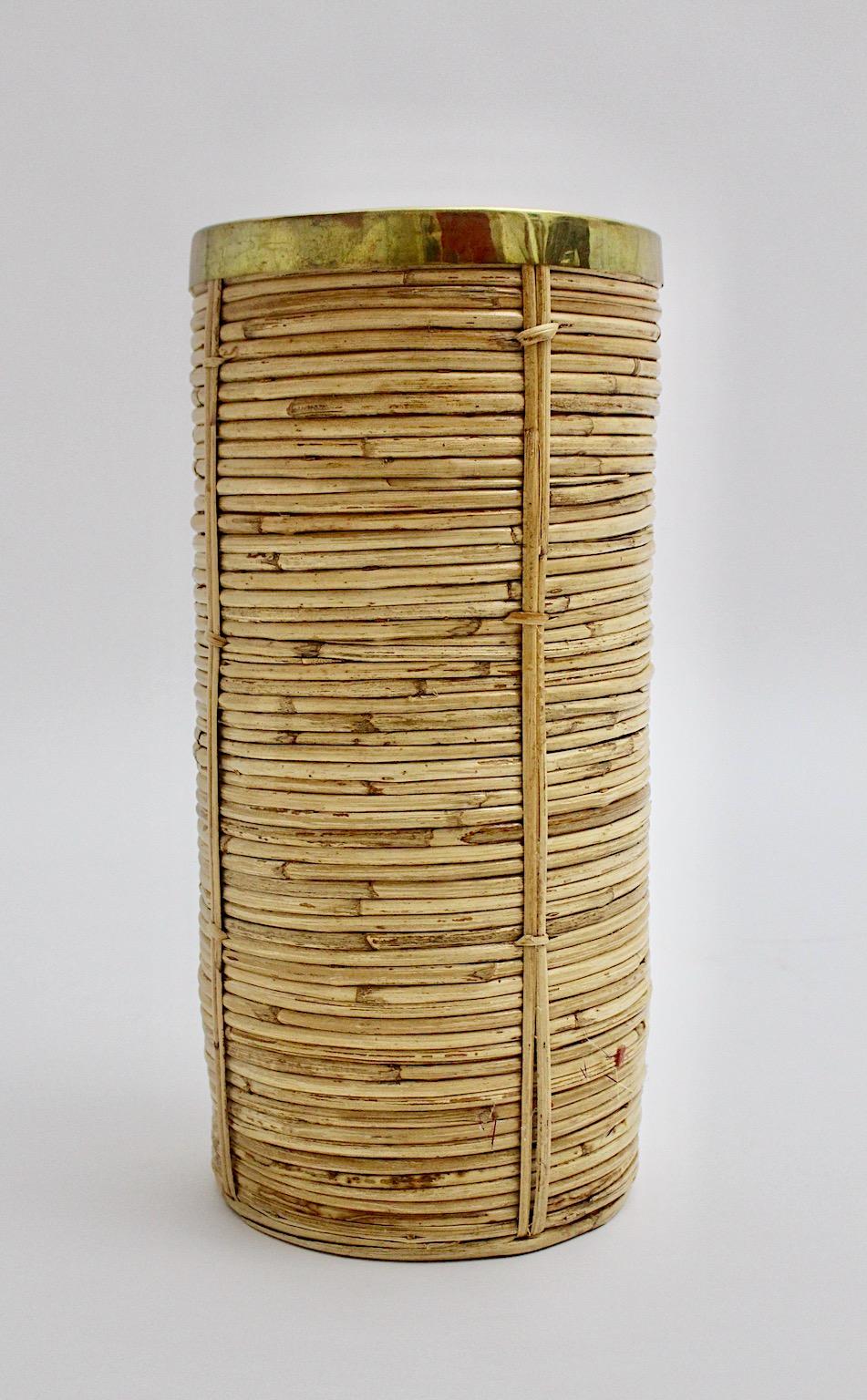 Hollywood regency style organic paper basket or cane holder from rattan and brass  1970s Italy.
An amazing paper basket from rattan work with a patinated brass trim could be a natural beauty in your entry room, anteroom or living space.
The beauty