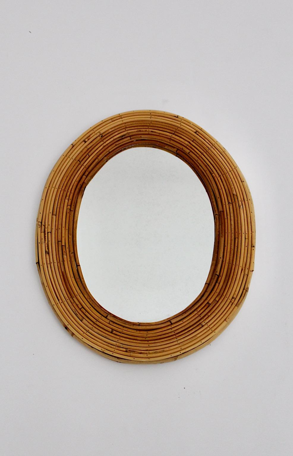 Riviera style vintage organic oval like wall mirror from rattan bamboo France 1950s.
The stunning oval wall mirror glass is framed with rattan bamboo wickerwork.
Very good condition, the rattan work shows through its organic material slightly