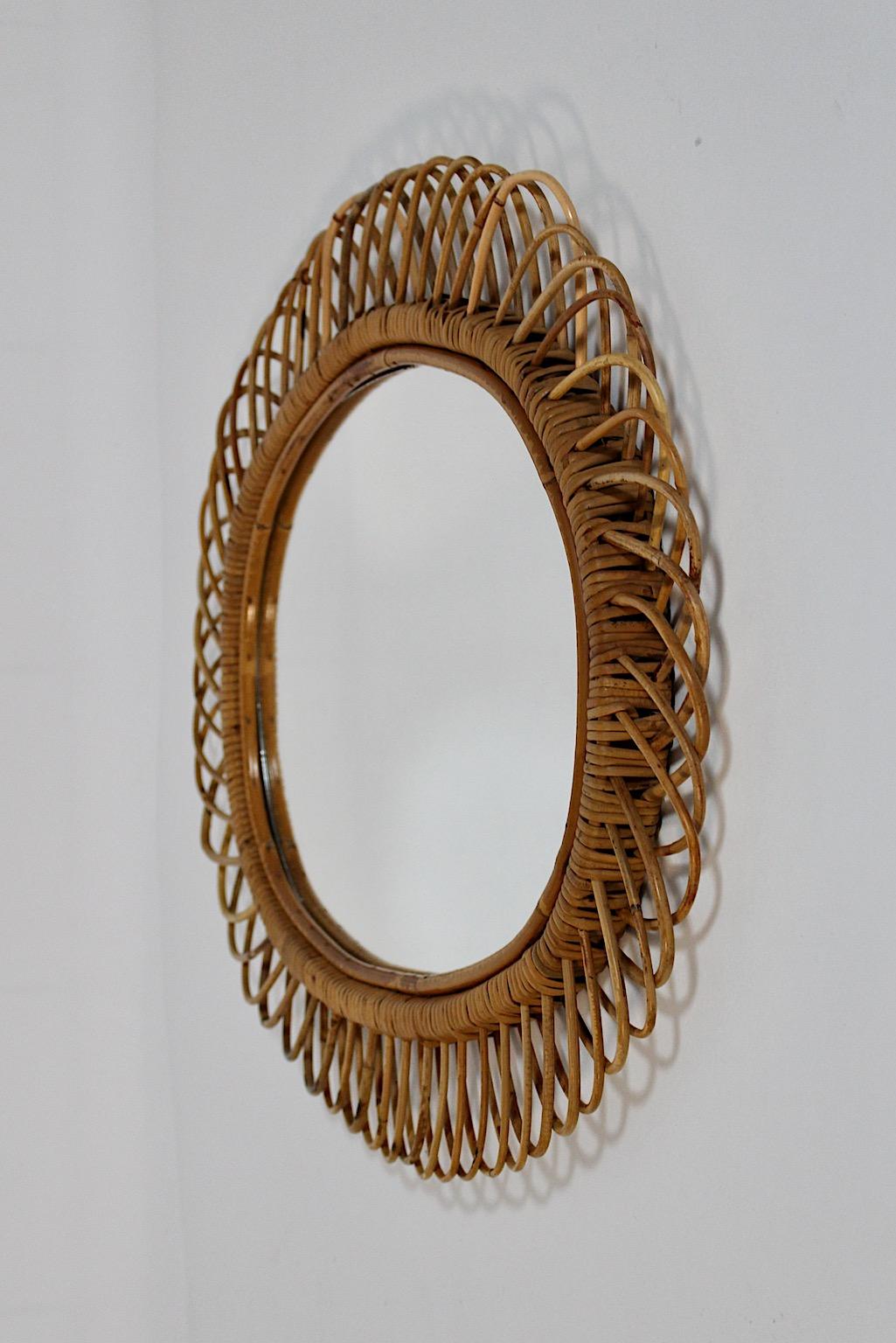 Miroir ou miroir mural en forme de soleil organique vintage Mid-Century Modern
en rotin et verre miroir, Italie, années 1960.
Bien que la grande taille de ce miroir en forme de soleil permette de l'accrocher en
dans une entrée ou autour d'une