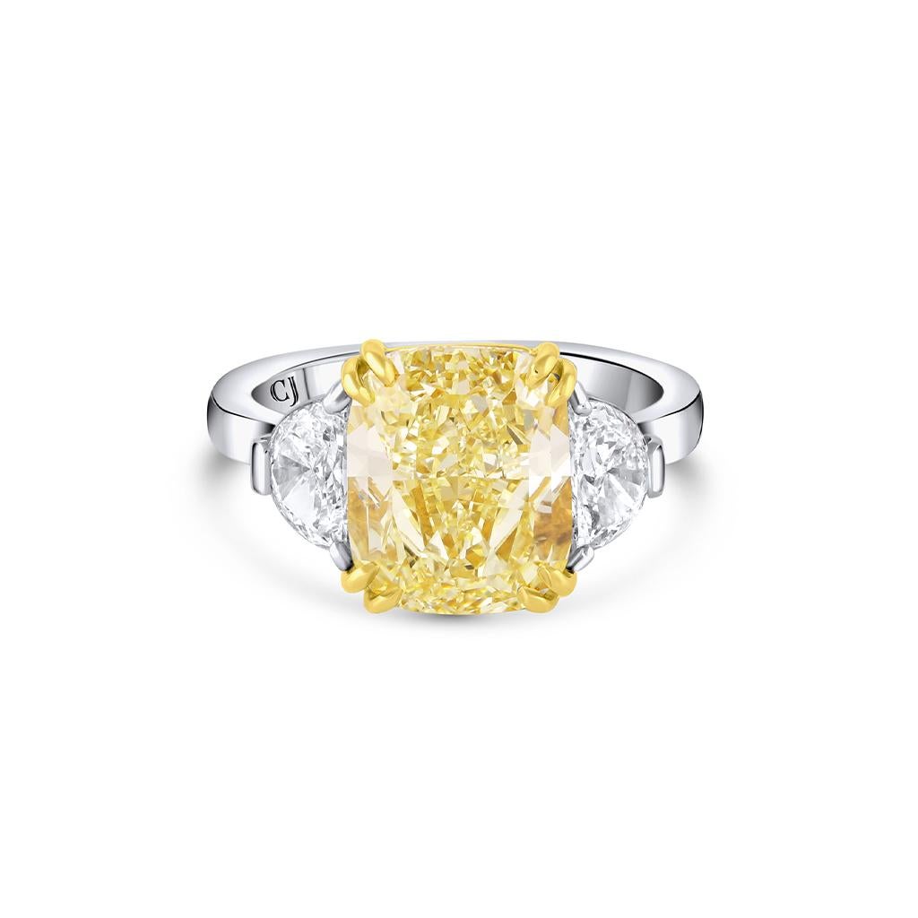 The Rivière Collection is exclusively designed and created in-house at CJ Charles Jewelers.

This elegant ring is crafted of platinum showcasing in the center a 5.01 carat fancy yellow cushion cut diamond. It also features two F colorless half moon