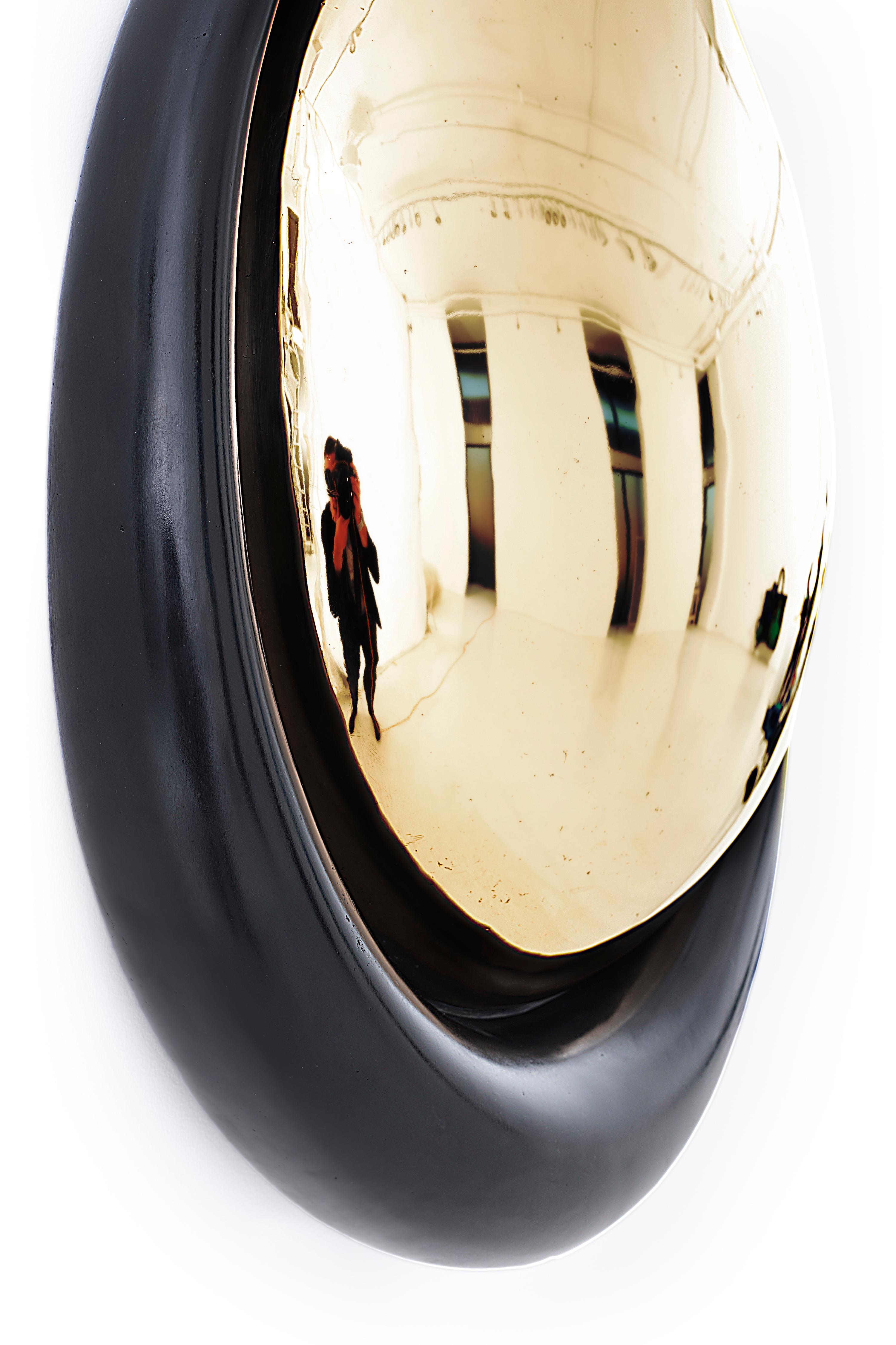 Rivoningo (To Reflect) is a wall sculpture that exploits the qualities of bronze to create an amorphic convex mirror. The bulbous and highly polished interior section offers a triple reflection. “This piece distorts your perception of self and