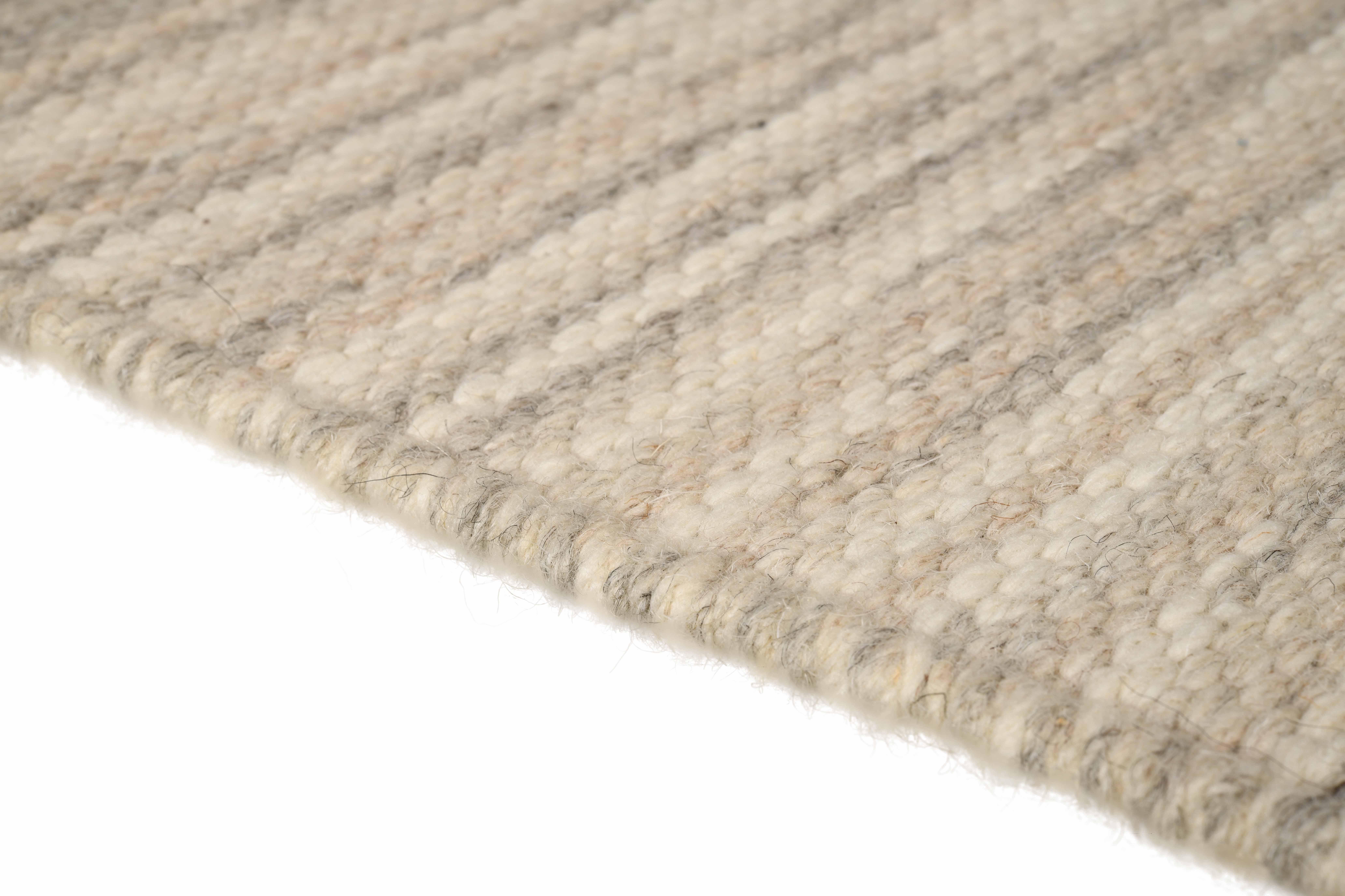 Rivus takes us on a journey like a graceful stream flowing aimlessly through the valleys. Undulating natural wool yarns meander thoughtfully through the high and low neutral tones, coalescing towards a subtle yet striking linear design.

