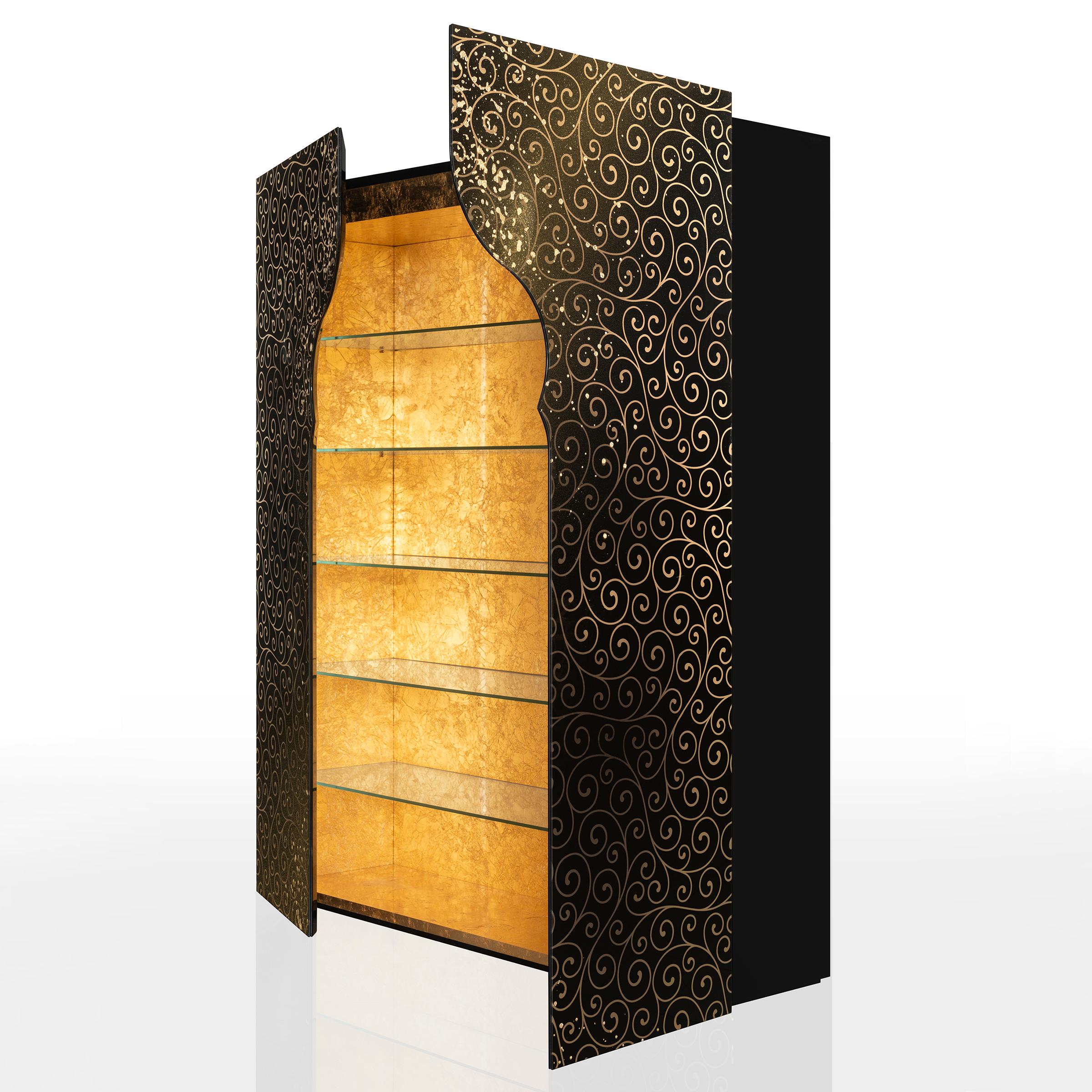 Armoire étagères Riyad avec structure de caisse en bois massif finition laquée noire,
avec 2 portes frontales en verre trempé façonné extra-clair, épaisseur 6mm, avec
fond noir décoré de feuilles d'or par sablage artisanal
et avec de la poudre dorée