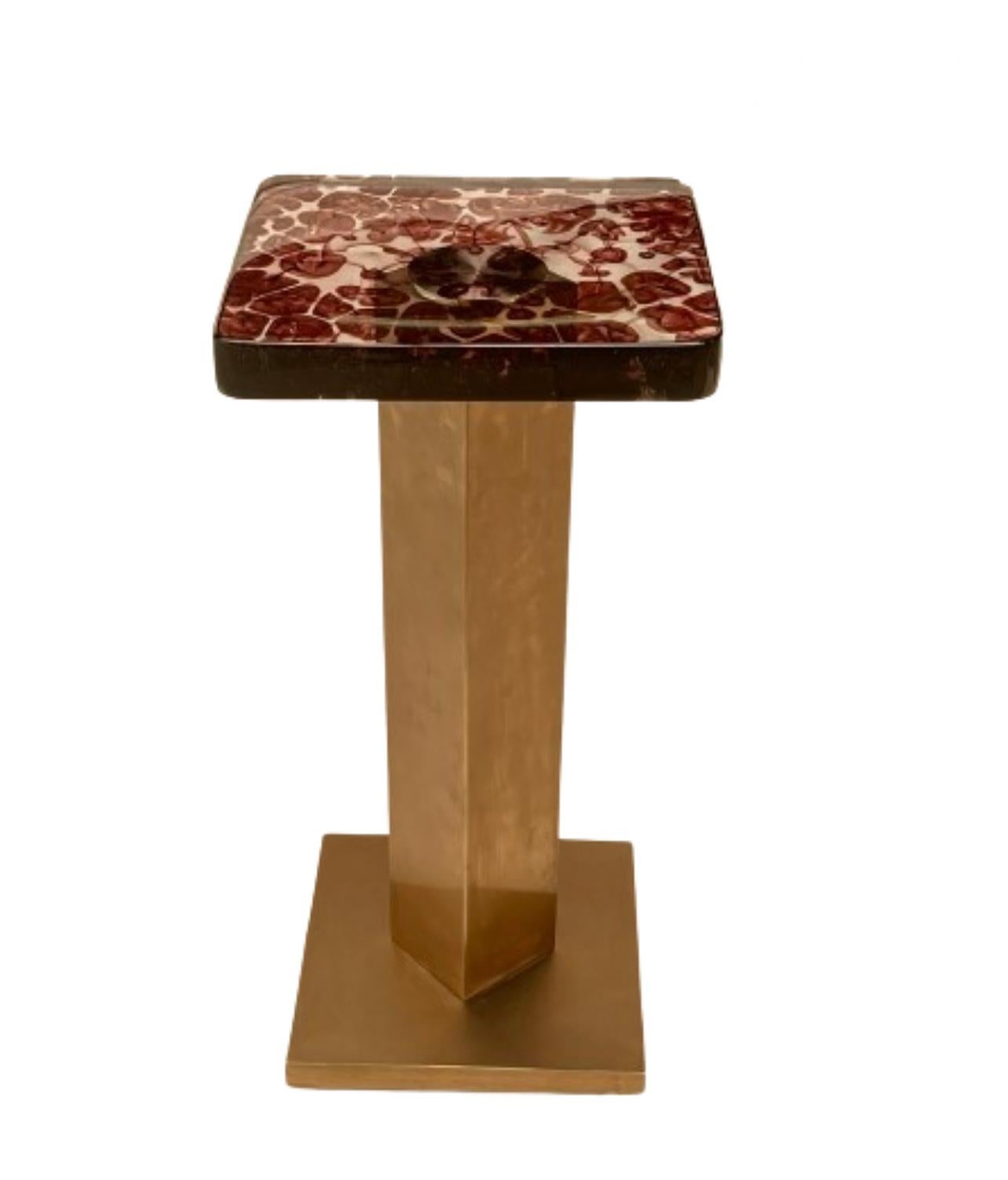 La RIZO Qube Plum est une table d'appoint moderne super chic qui respire l'élégance contemporaine avec sa combinaison frappante de matériaux et son design minimaliste. Le plateau de la table présente une surface carrée fabriquée à partir d'un verre