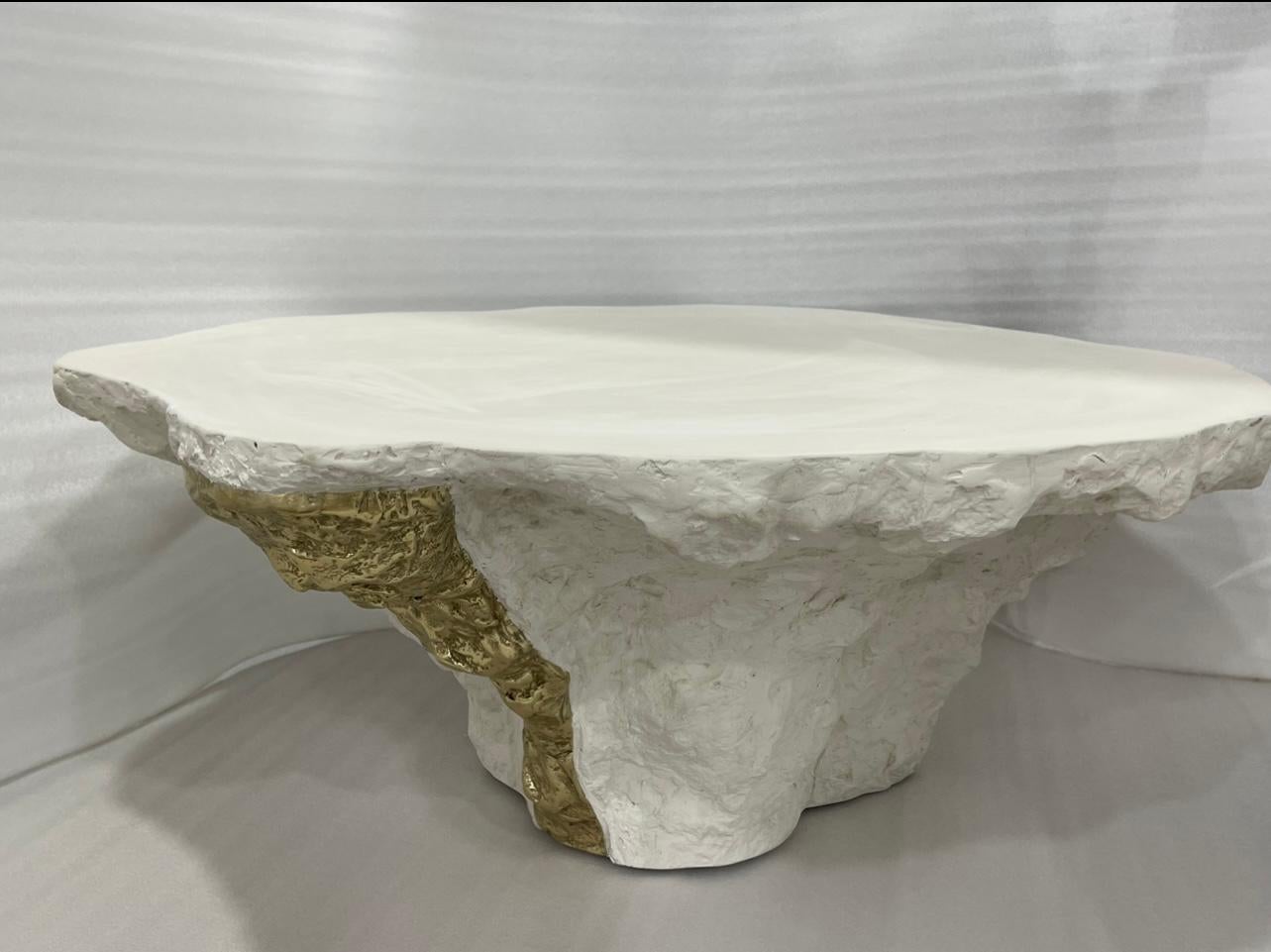 Der skulpturale Roccia Gelerio-Mitteltisch von RIZO verkörpert mit seiner einzigartigen Form, Textur und MATERIALität zeitgenössisches Design mit künstlerischem Flair. Die starke, aber organische Form, die aus gemischten Materialien geschnitzt ist,