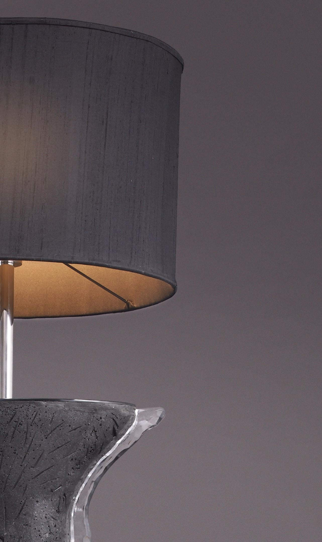 Marrying the fine with organic materiality, the mixed-media Silhouette floor lamp is handcrafted in carbon with a signature crystal shadow and is shielded by a rich woven silk lampshade. With its bold, curvaceous form, luminosity and functionality,