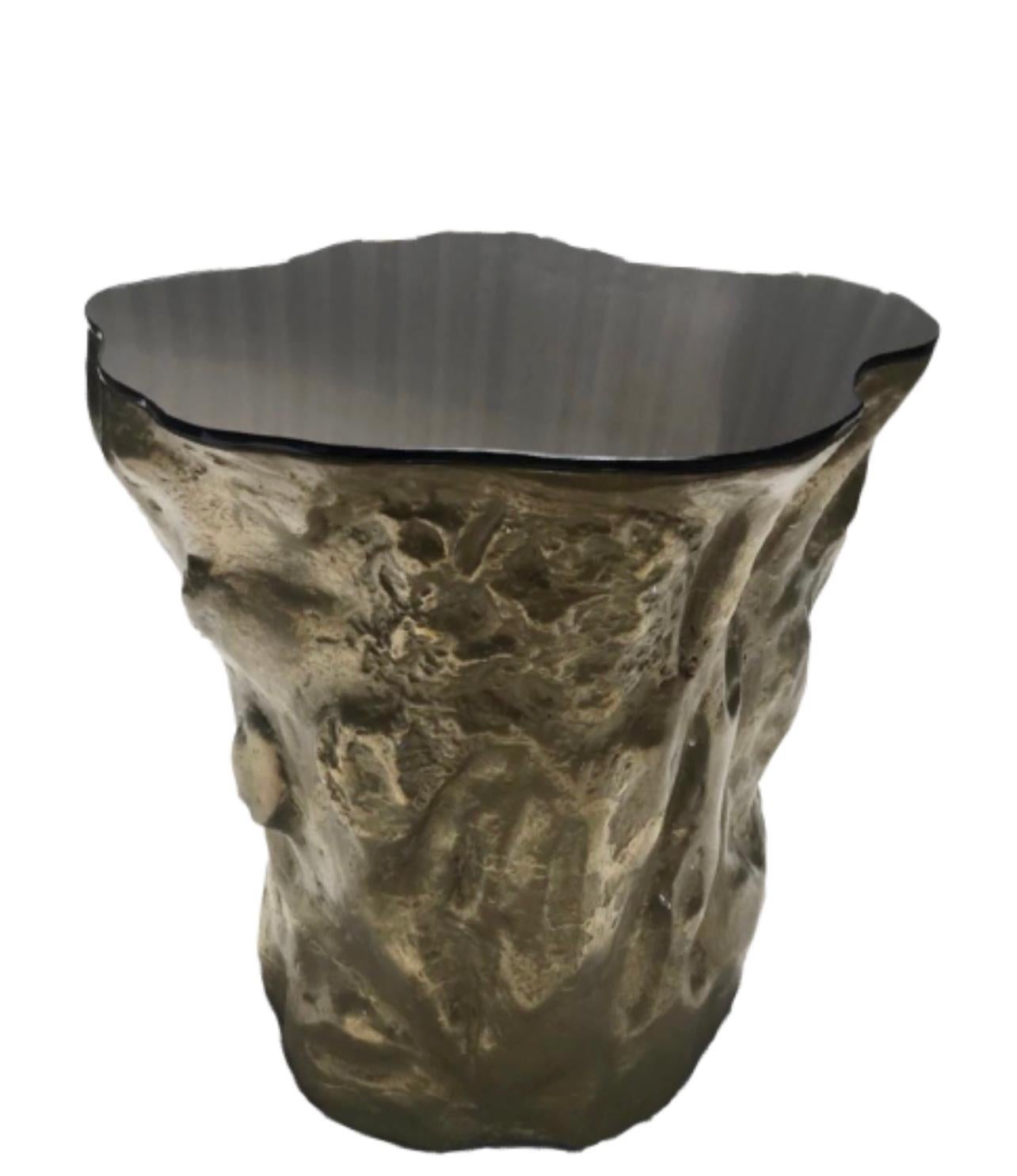 The Strom series is a nature inspired furniture design with more than an organically sculpted form to present. The base illustrates a charismatic part of a tree trunk in molten patinated brass finish and the fine metallic glass top brings a