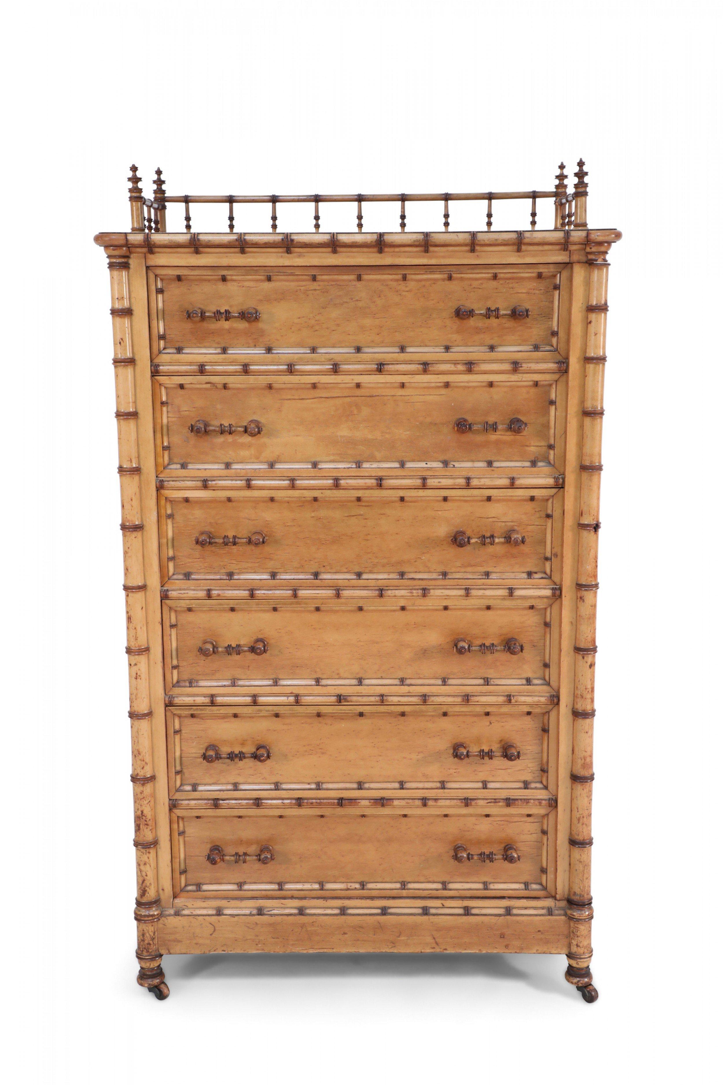 American Victorian Aesthetic Movement amber stained birdseye maple faux bamboo 6-drawer lock side chest with a partial gallery top, paneled sides, and turned wooden handles resting on brass casters. (R.J. Horner).
  