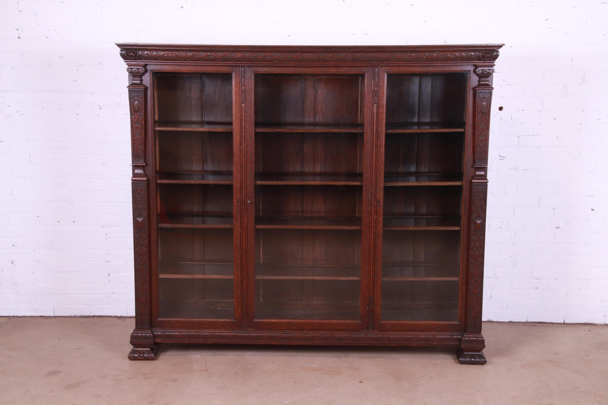 R.J. Horner Antique Renaissance Revival Carved Oak Glass Front Triple Bookcase In Good Condition In South Bend, IN