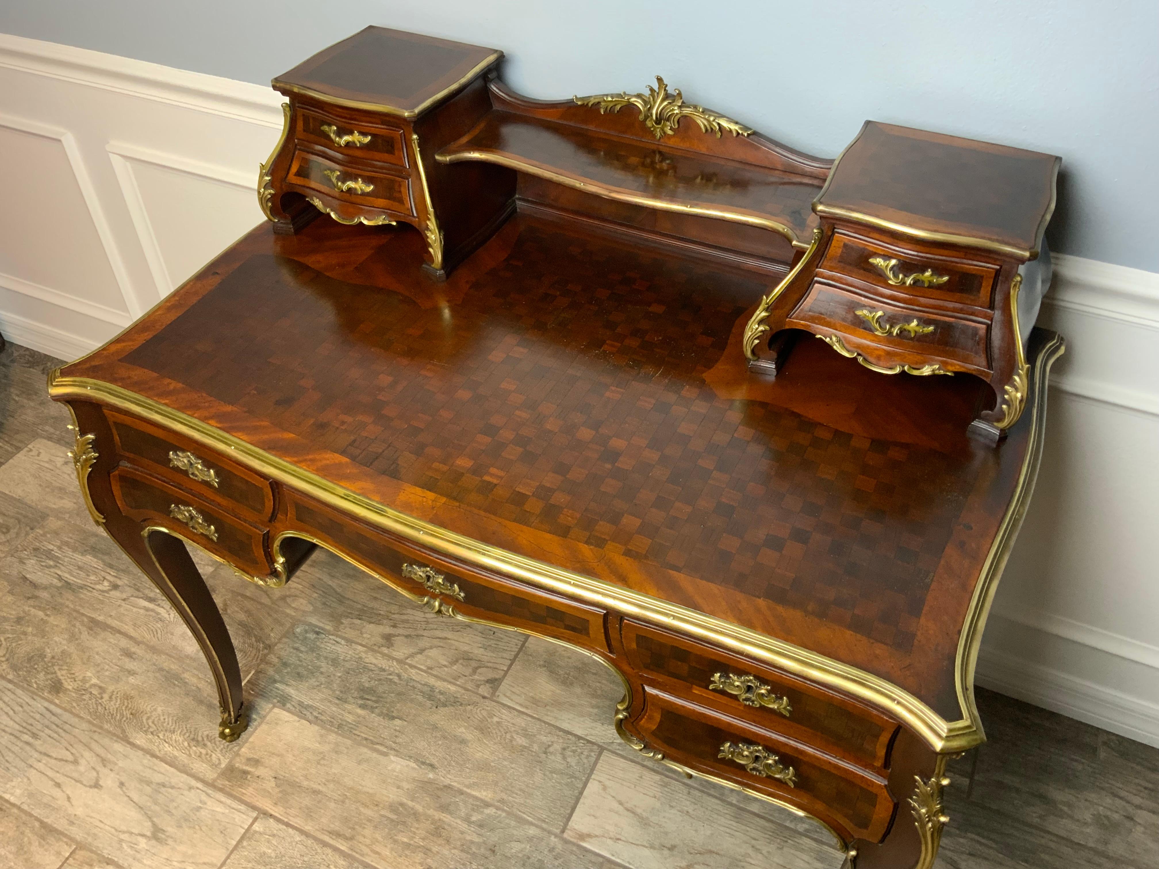 A beautifully proportioned serpentine shaped Louis XV1 style parquetry desk by R. J. Horner with heavy Brass trim and bulbous shaped sides.  This pieces is showing the early type makers label from New York, N.Y.  R.J. Horner did also import some