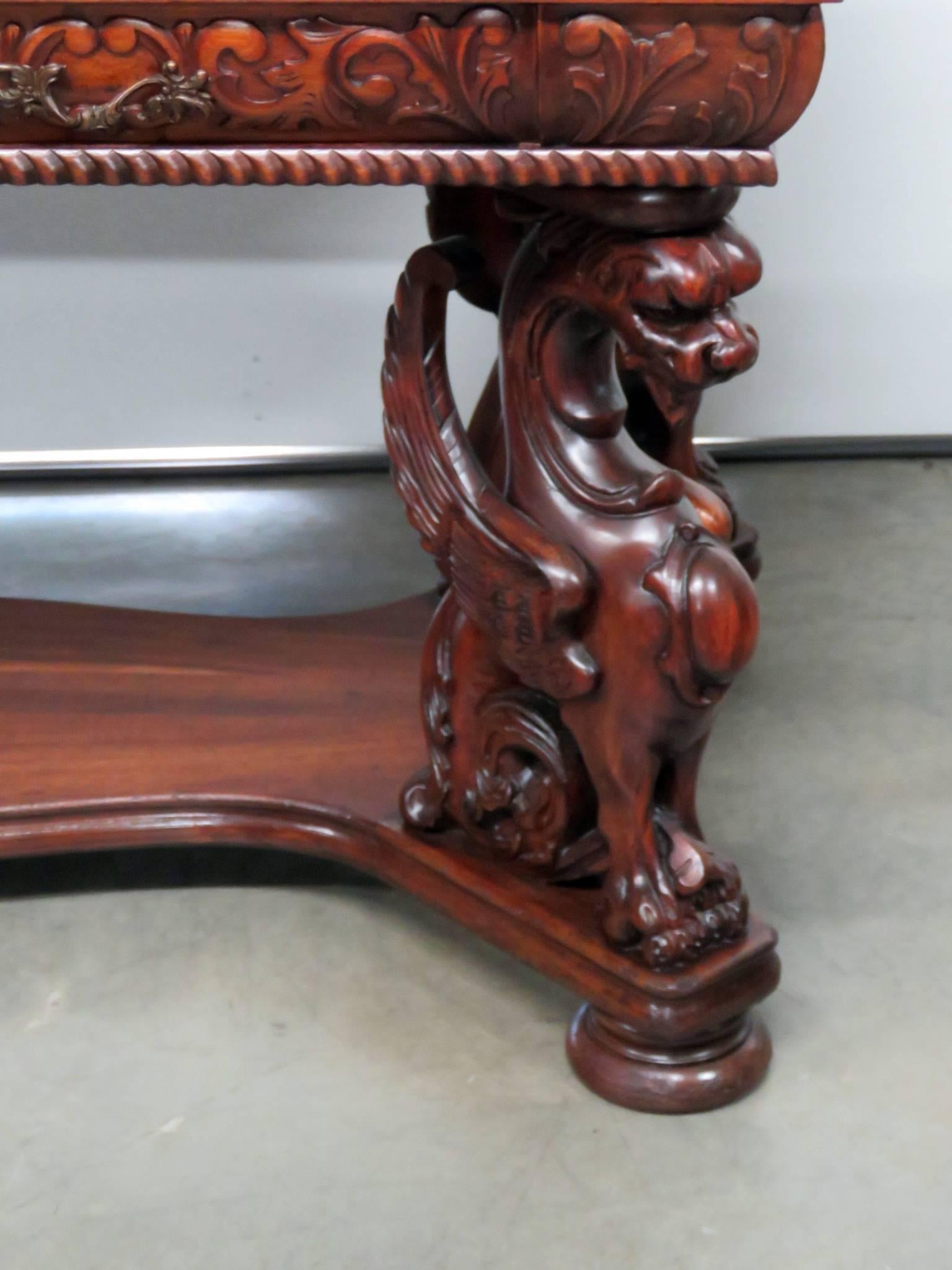 This is an iconic RJ Horner desk. This classic RJ Horner Renaissance style carved mahogany winged griffin desk can be used as a center table or writing table. It is beautifully carved of solud mahogany with oak secondary woods and is in good