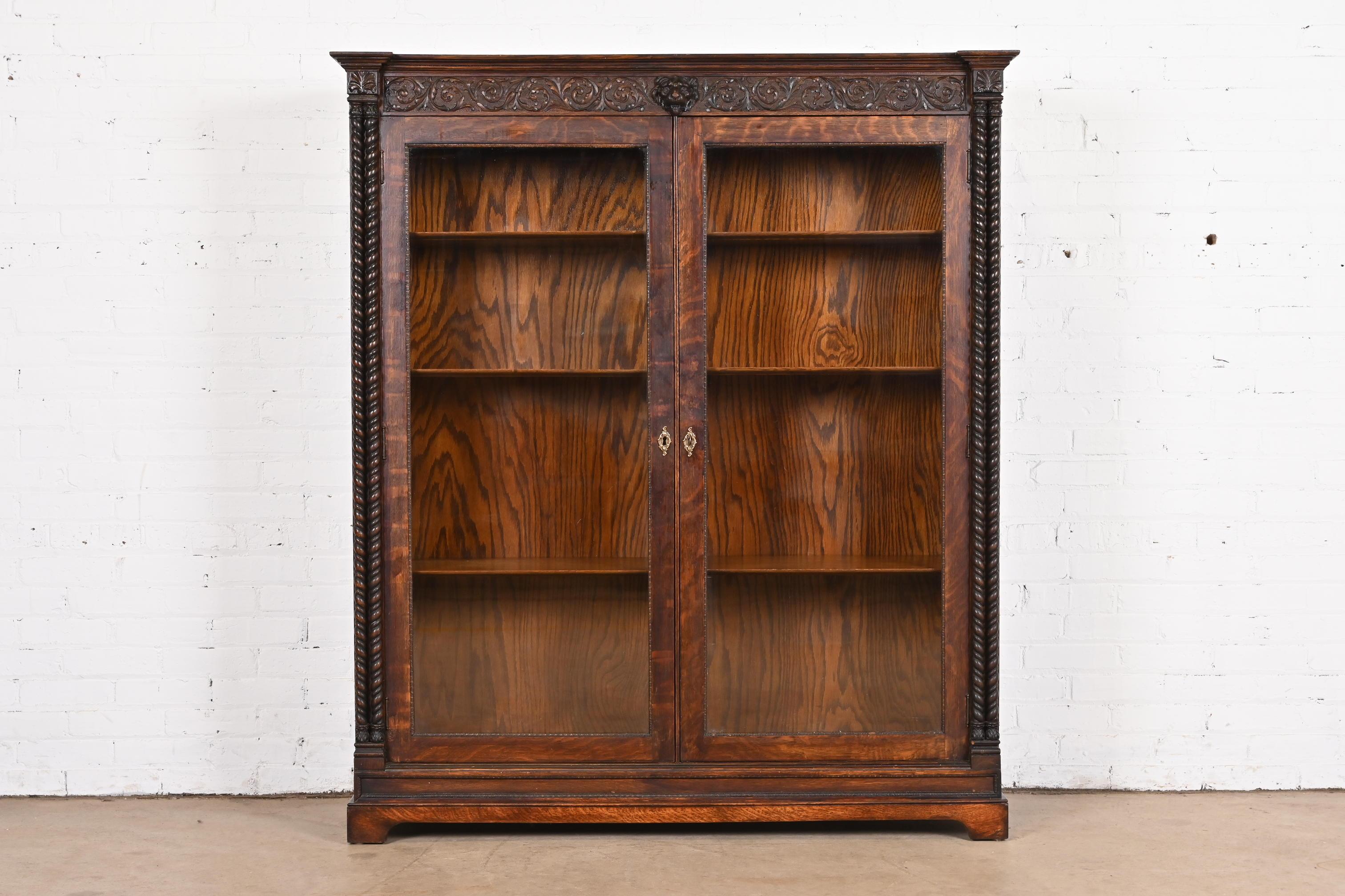 A gorgeous antique American Empire or late Victorian double bookcase

In the manner of R.J. Horner

USA, Circa 1890

Beautiful quarter sawn oak, with carved lion head and foliage, glass front doors, and brass hardware. Cabinet locks, and key is