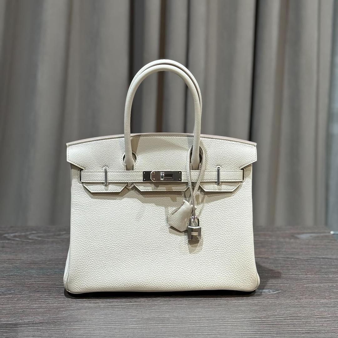Jewels Aficionado bietet die Hermès Birkin 30 aus Beton Togo-Leder an, einen modernen Klassiker in einer raffinierten neutralen Farbpalette. Der glatte, elfenbeinfarbene Kreideton mit zarten grauen Untertönen harmoniert wunderbar mit der genarbten