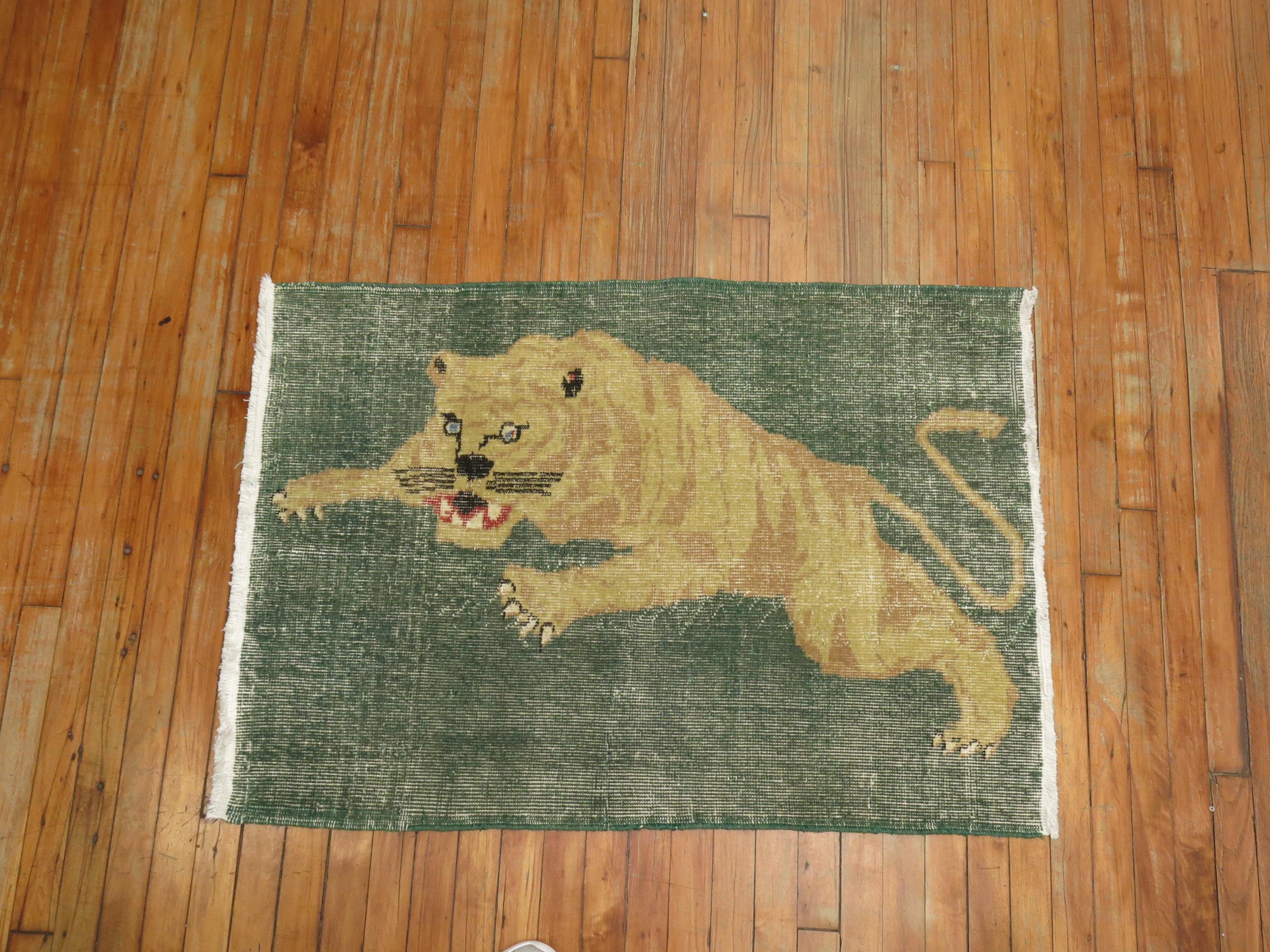 A late 20th century one of a kind shabby chic Turkish rug depicting a tiger roaring on a green field.

Measures: 31