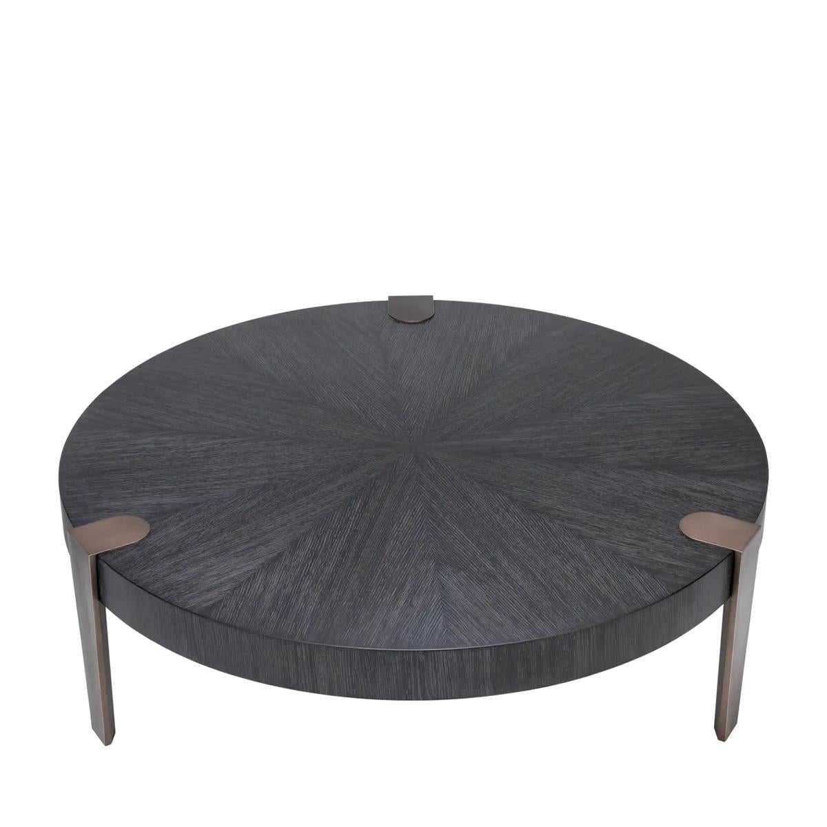 Table basse Robald avec plateau en bois en chêne gris 
Placage avec 3 pieds en acier en finition bronze antique.