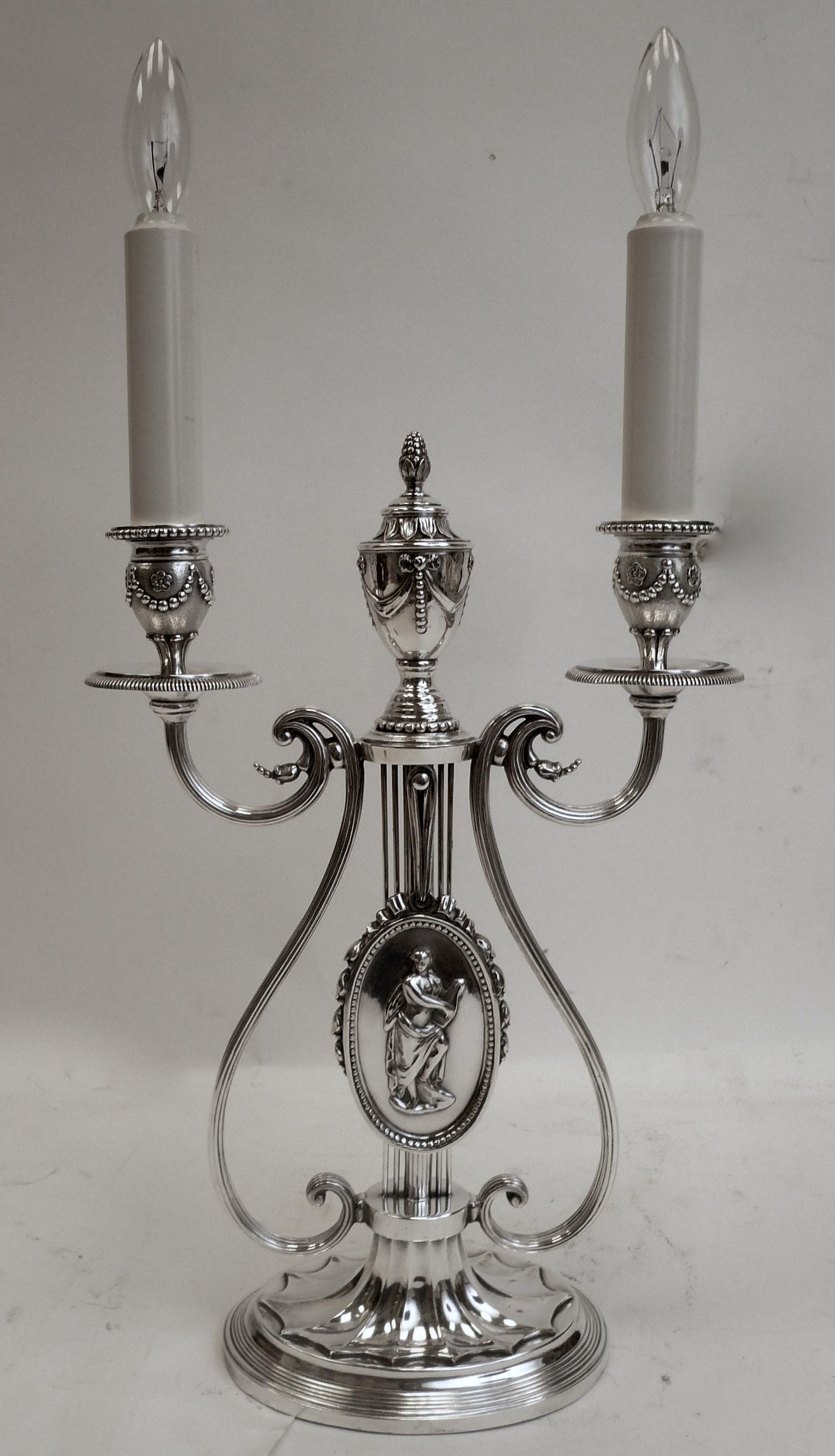 This Georgian style lyre form lamp by Caldwell features neoclassical motifs, including urns, swags, and bowknots.