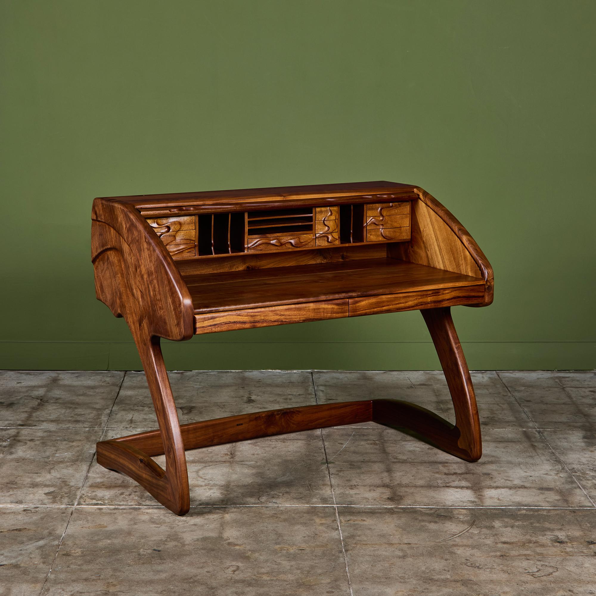 This stunning cantilevered walnut studio craft desk, by California design couple Robert and Joanne Herzog c.1986, is a showstopper. The piece features a roll top desk with interior shelves and drawers, all lined with a stormy blue gray felt as well