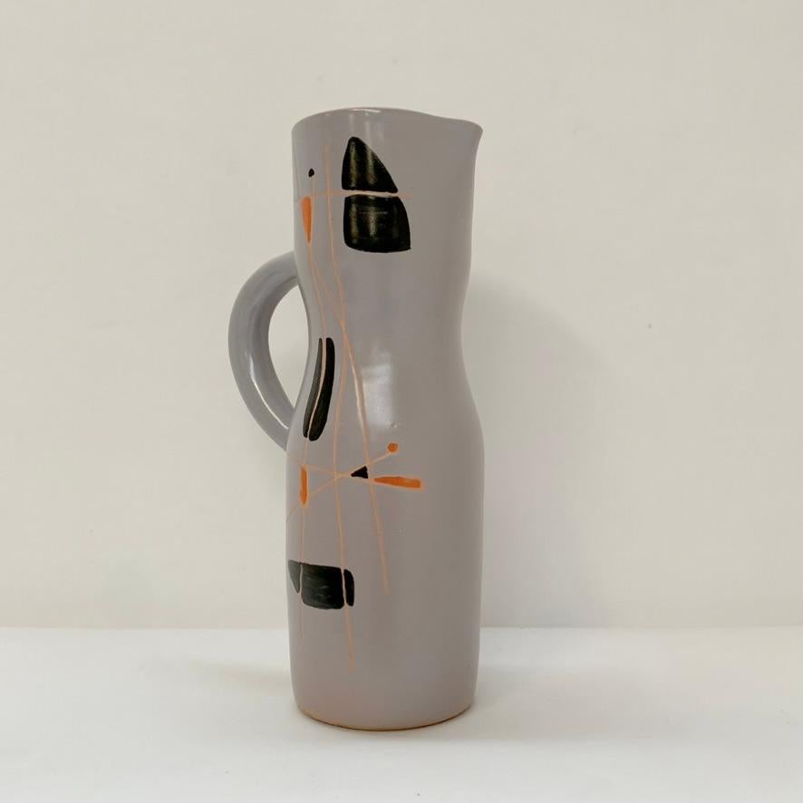 Der schöne Robert Auguste und Gyn Gausserand  Signierter Keramikkrug, um 1956, Frankreich.
Grau emaillierte Keramik, handbemalt mit abstrakten Mustern in Schwarz und Orange.
Darunter unterschrieben: R & G Auguste.
Abmessungen: 30 cm H, 16 cm B, 11