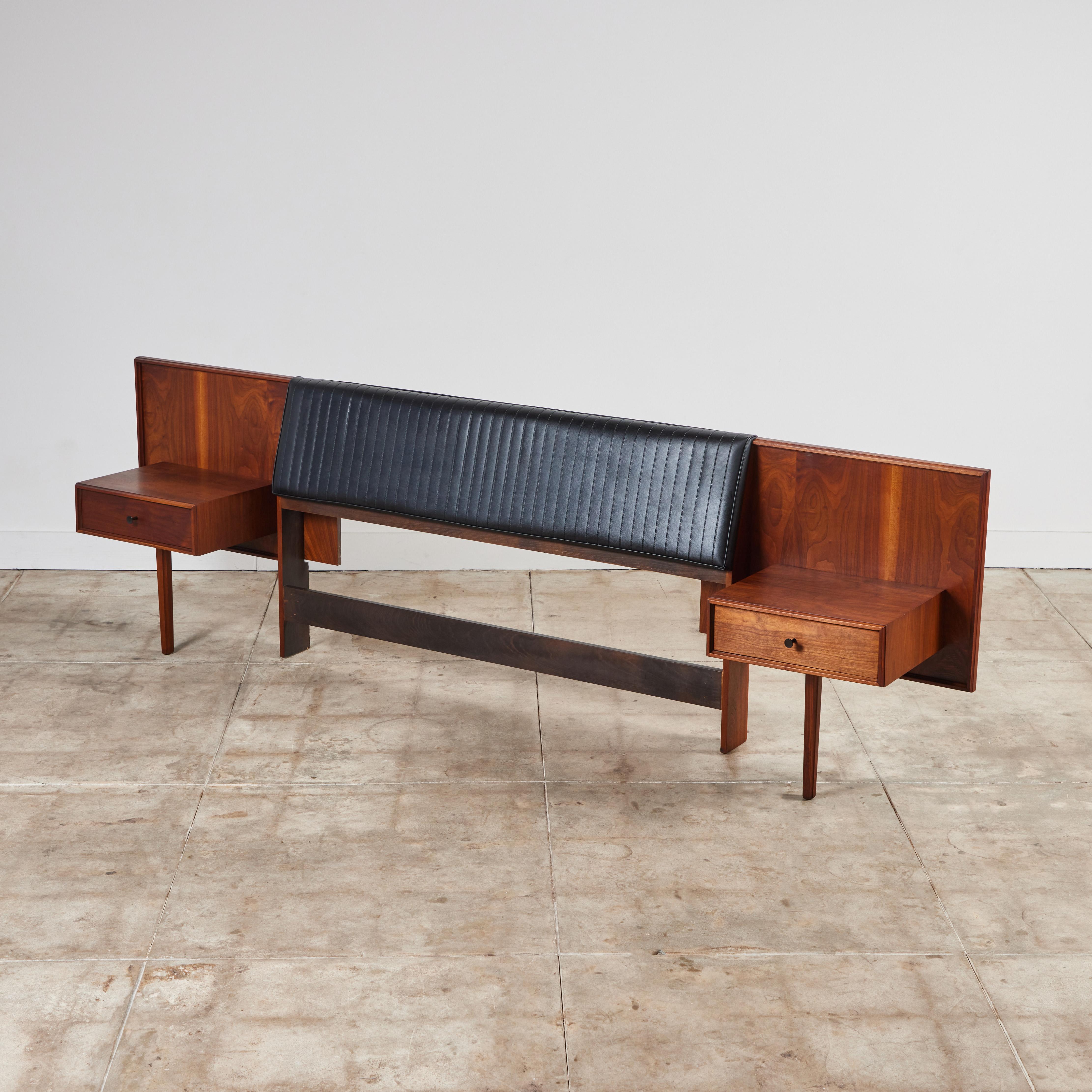 Queen size headboard by Robert Baron for Glenn of California c.1960s, USA. The walnut headboard features a vertical stitched leather headrest with attached night stands. Each night stand has one drawer with black enameled pulls.

Dimensions
118