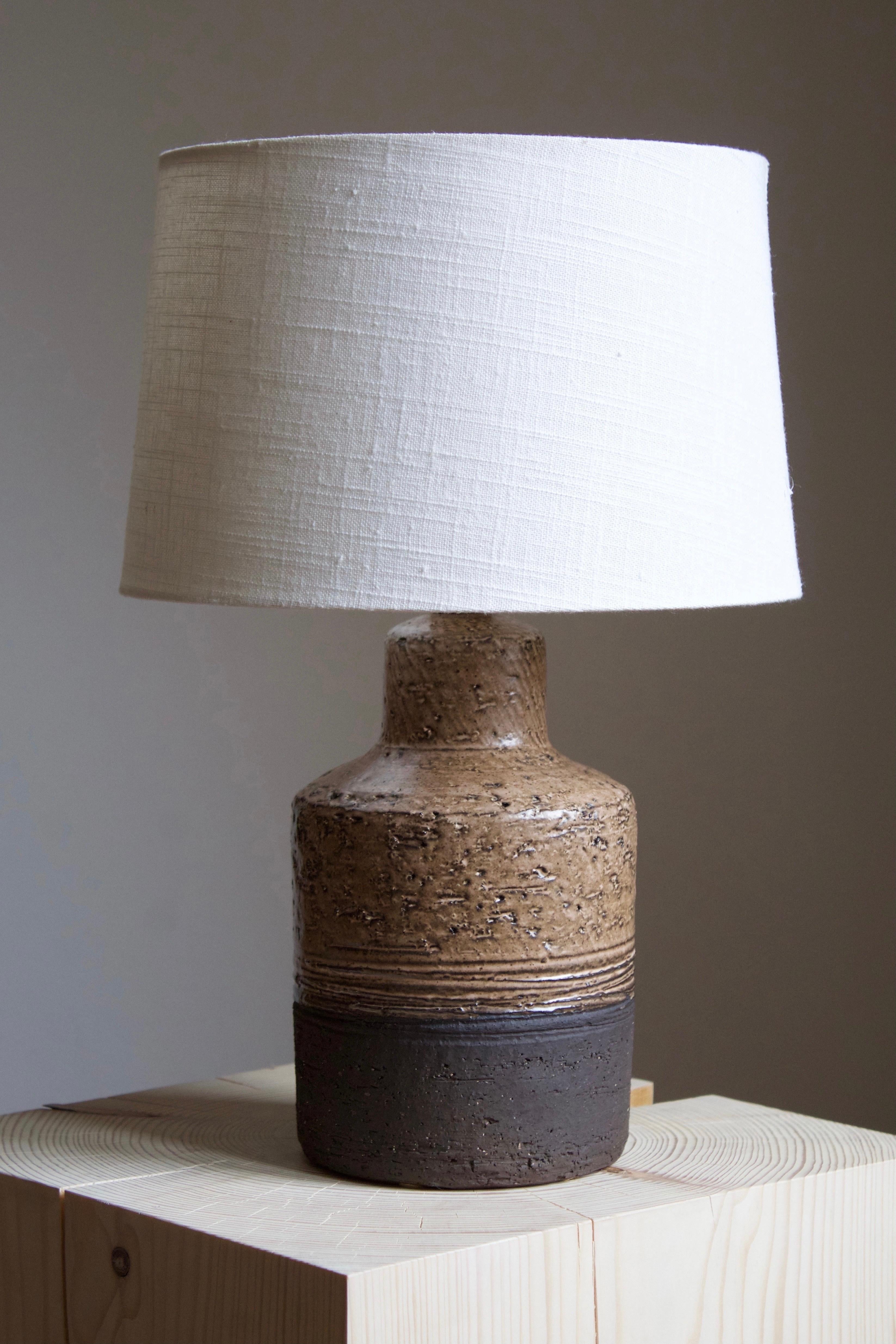 A table lamp, designed and produced by Robert Bentsen, in his studio, Denmark, 1960s. 

Sold without lampshade. Stated dimensions exclude the lampshade.

Glaze features brown-grey colors.