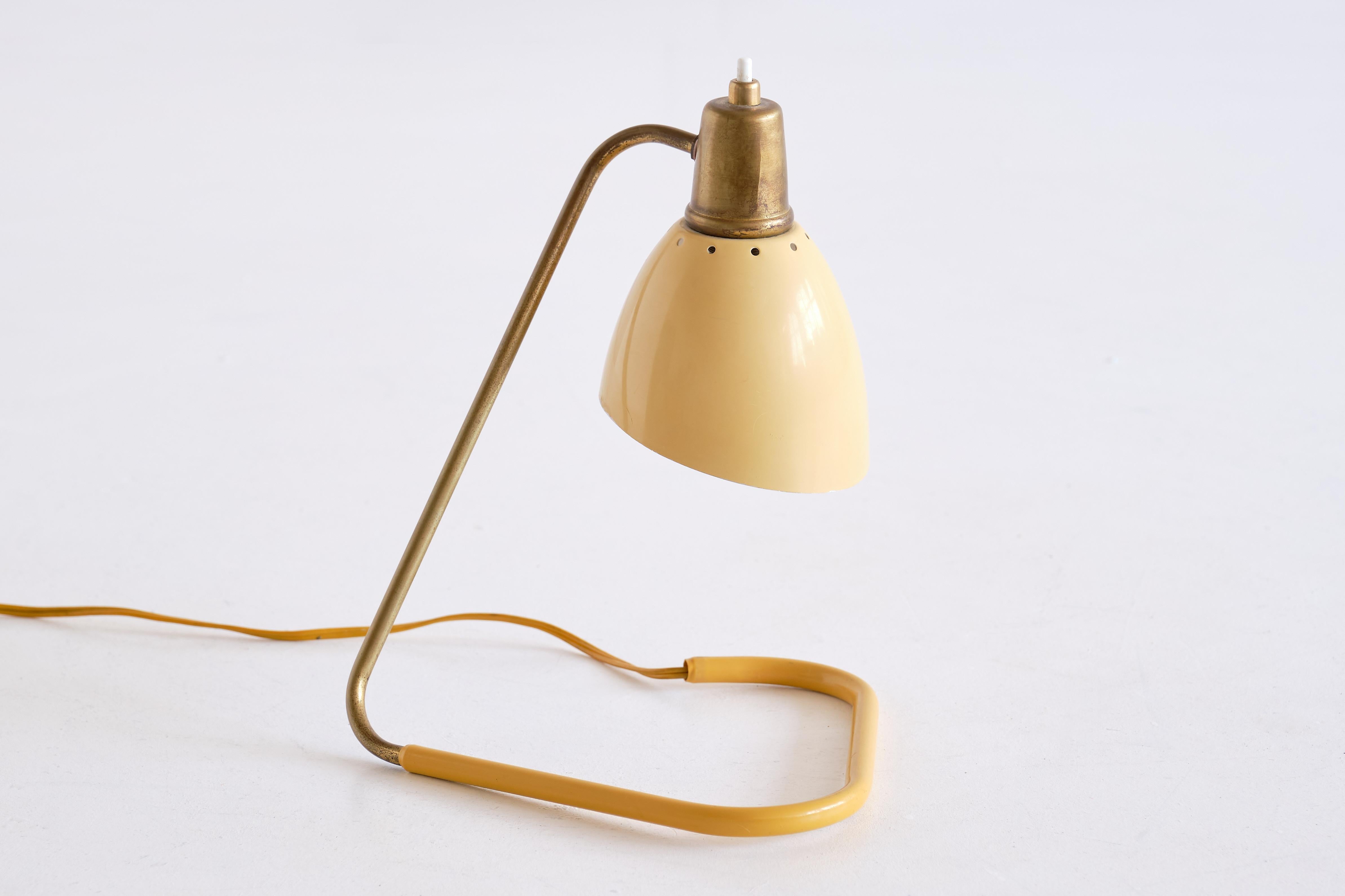 This charming table lamp was designed by Robert Caillat and produced in France in the 1950s. This particularly rare design is sometimes (mis)attributed to Jean Boris Lacroix Brass stem with a pale yellow adjustable shade with a brass top and push