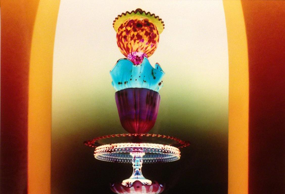 Untitled - Still life tower of glass w/ jewel tone colors in yellow archway - Photograph by Robert Calafiore