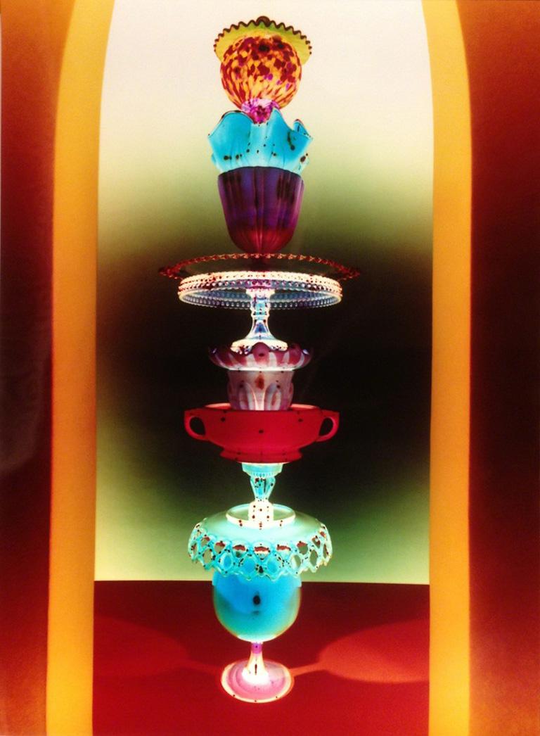 Robert Calafiore Color Photograph - Untitled - Still life tower of glass w/ jewel tone colors in yellow archway