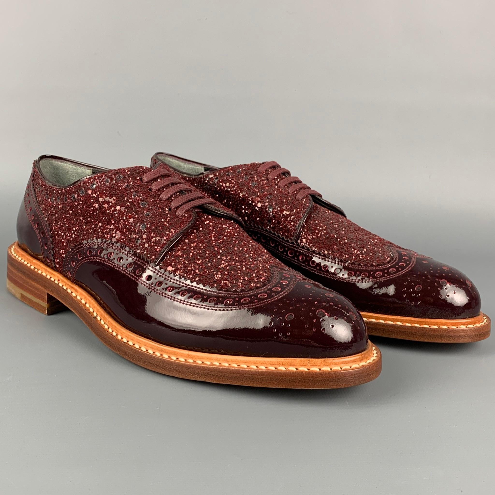 ROBERT CLERGERIE shoes comes in a burgundy patent leather featuring a wingtip style, glitter panel, and a lace up closure. Made in France. 

Excellent Pre-Owned Condition.
Marked: B 08 1042 25

Outsole: 11 in. x 3.75 in. 