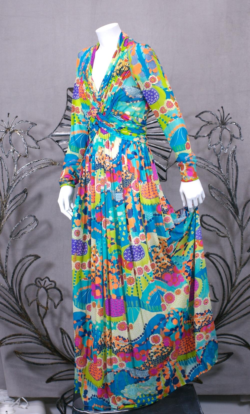 Robert David Morton Draped Jersey Gown in semi sheer nylon jersey with draped bodice and full skirt in vibrant colorful florals. Fabric is draped down neckline and interlaces to continue into a faux draped sash on back. 
Sleeves are semi sheer,