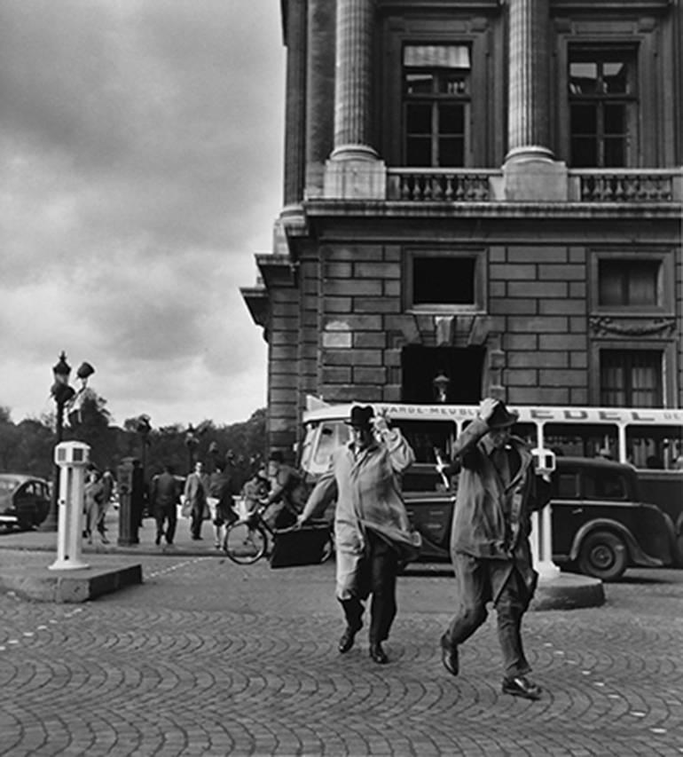 Black and White Photograph Robert Doisneau - Coup de Vent Rue Royale