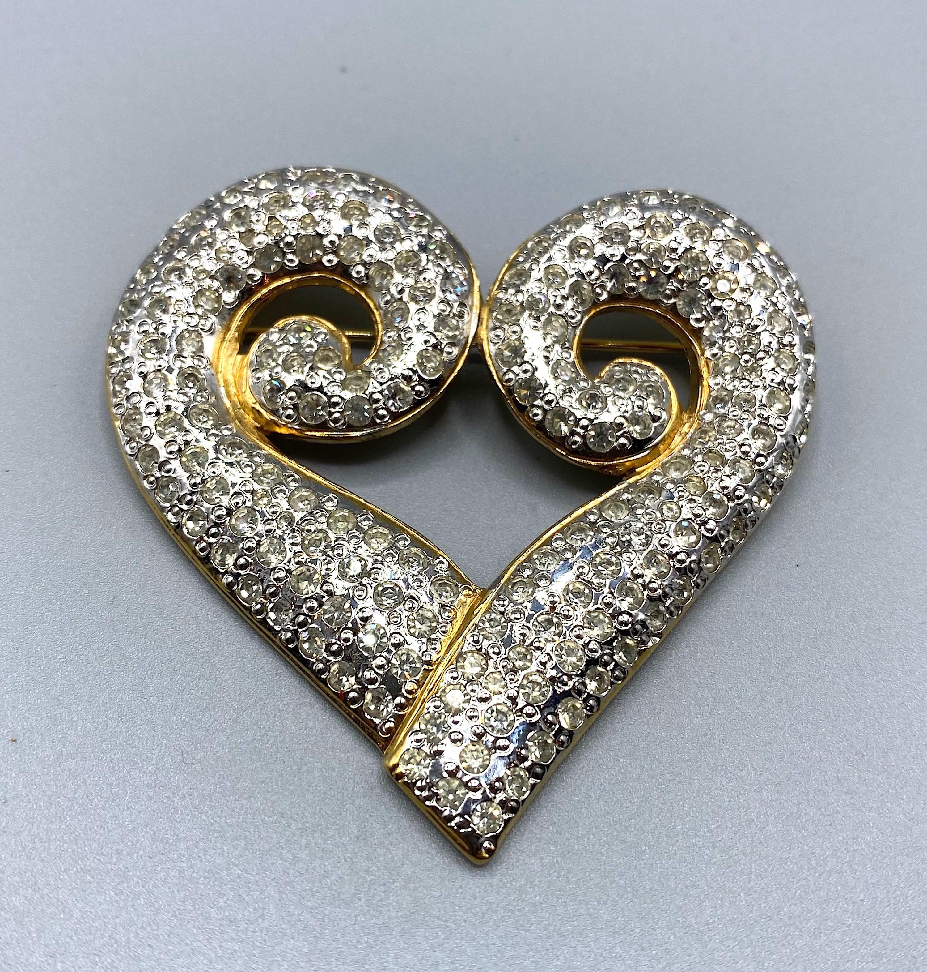 Beautiful gold and rhodium brooch by Robert Goosens design for Yves Saint Laurent in the shape of a heart.
This brooch is studded with rhinestones, which gives it extreme brightness
Signed YSL on the back.
Measures 2.5
