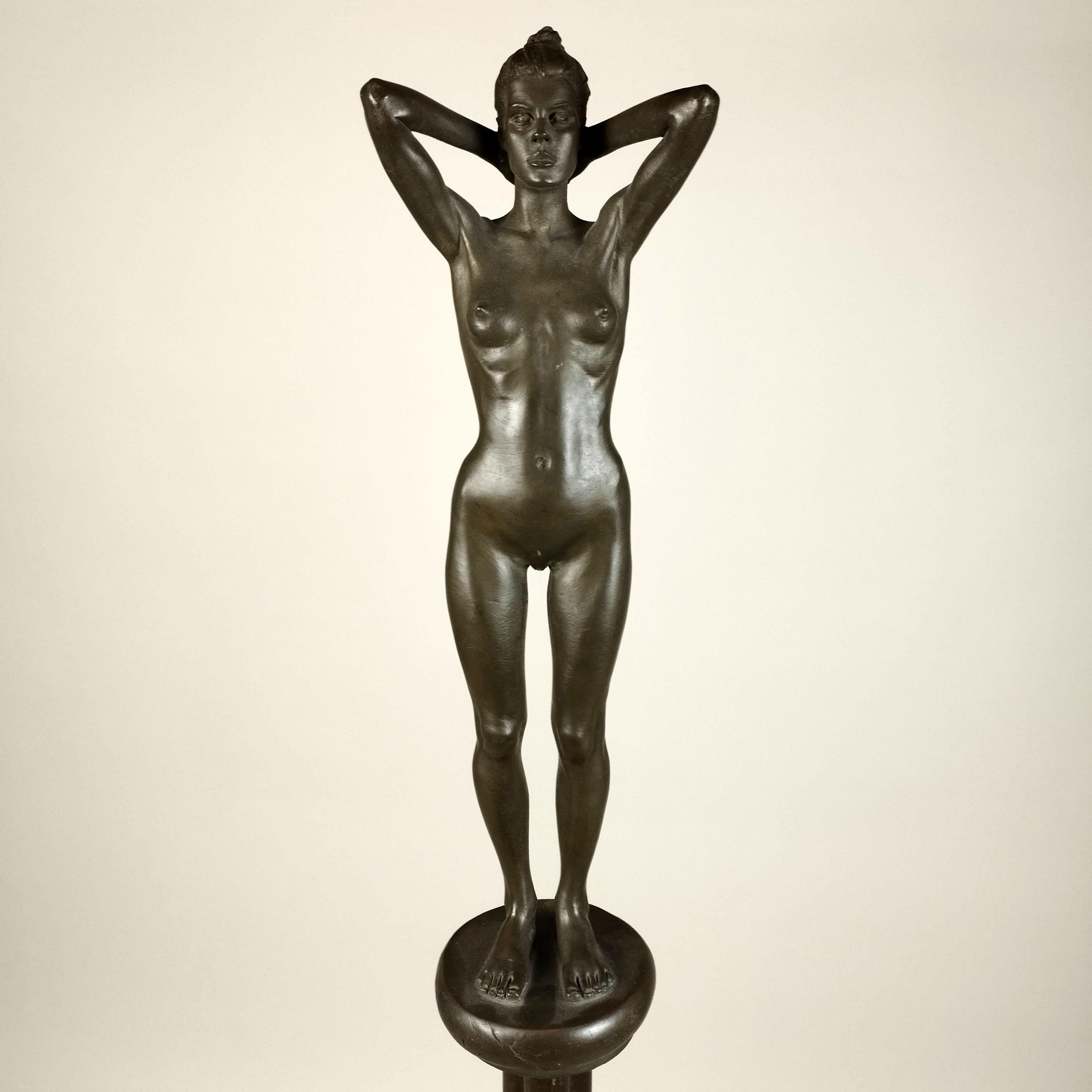 A bronze sculpture with tripod base by Robert Graham, Mexican - American sculptor who lived in Los Angeles. The sculpture depicts a standing female figure with her arms behind her head. Unsigned. Featured on the Robert Graham exhibition book