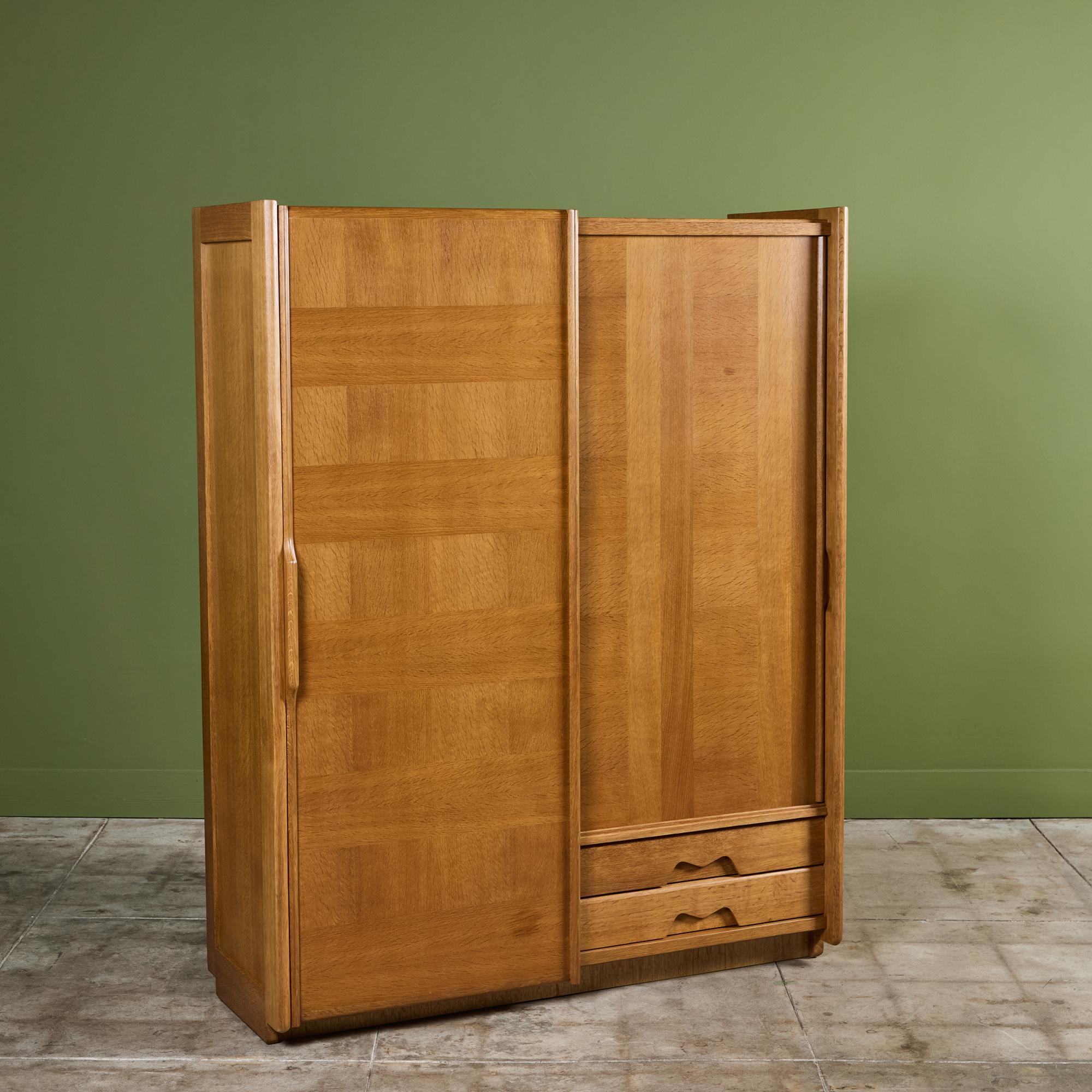 Splendido armadio in legno di Oak disegnato da Guillerme et Chambron negli anni '70 circa, Francia, della Votre Maison Edition. Questo armadio è dotato di due ante scorrevoli in Oak e di un contenitore interno. Un lato ha due ripiani e uno spazio