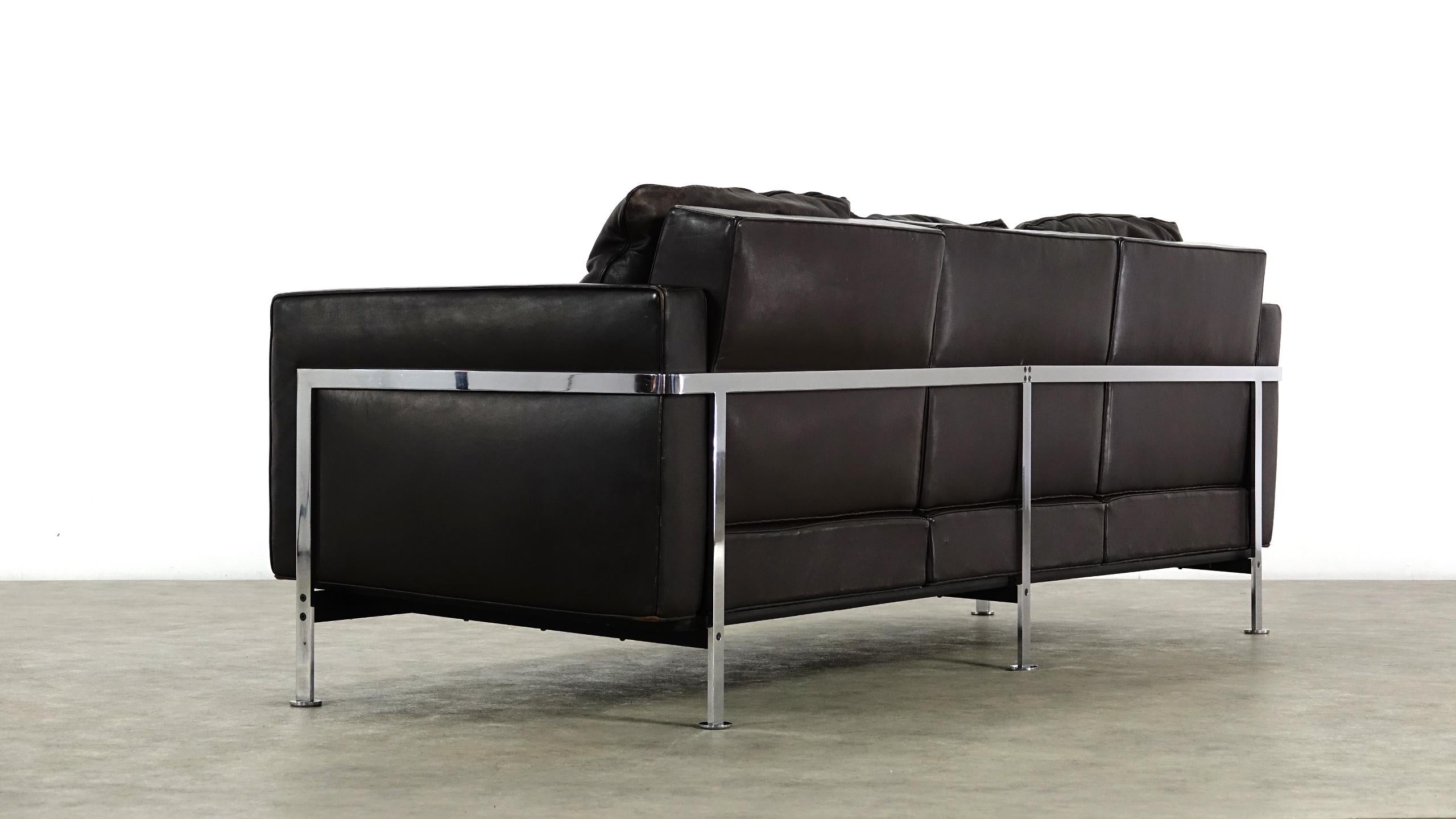 A comfortable three-seat design by Robert Haussmann RH 302 from De Sede. Design from 1954-1956. Construction of chrome-plated flat steel, body and down cushion covered with dark chocolate leather. Signs of age-appropriate use, the leather is
