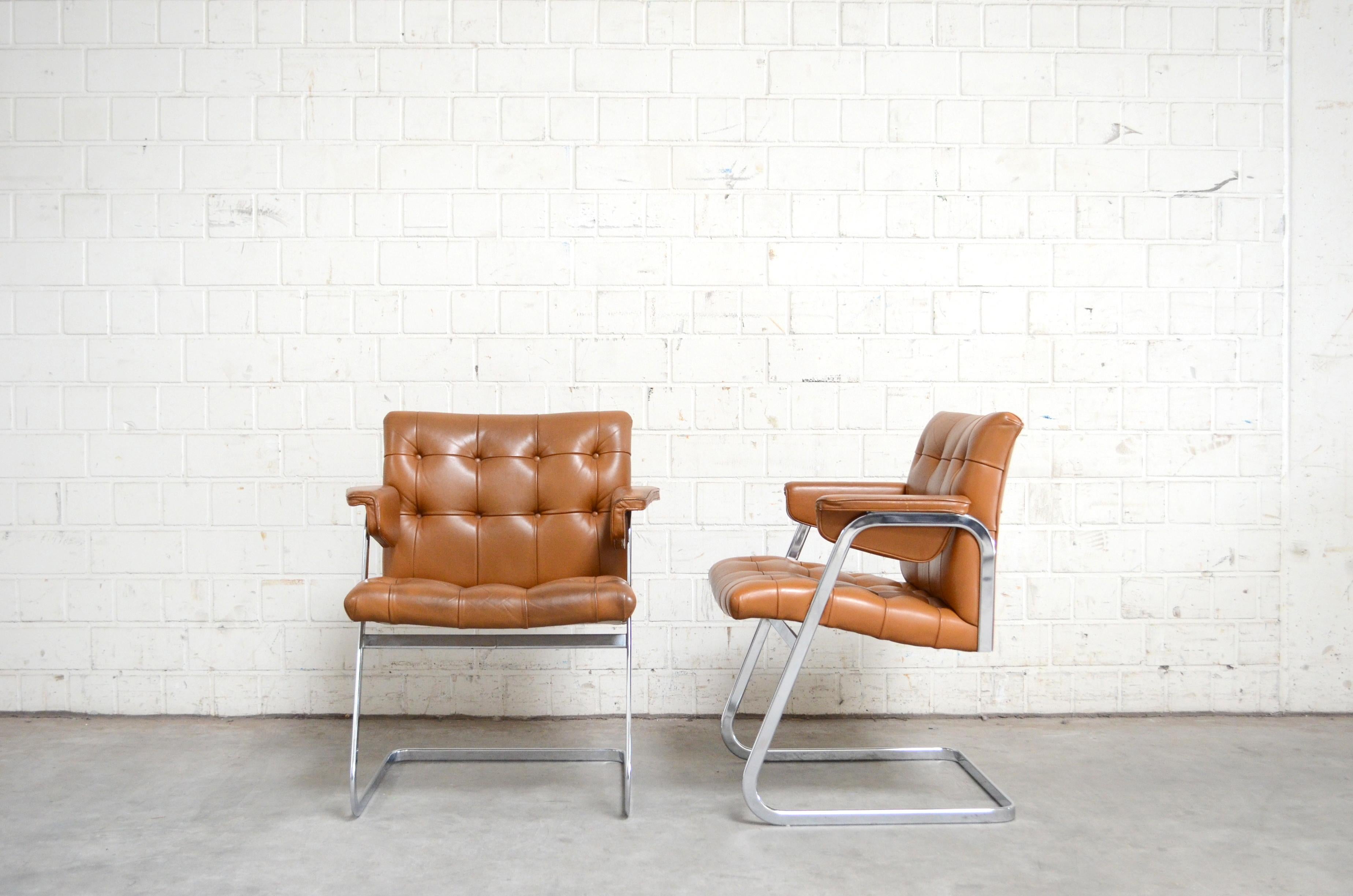 Robert Haussmann RH 305 armchairs design of 1957 and manufactured by De Sede.
Brandy cognac leather. The leather was recoloured some years ago from a leather company.
This version from 1970s is very rare version with Softpad armrests.
The design