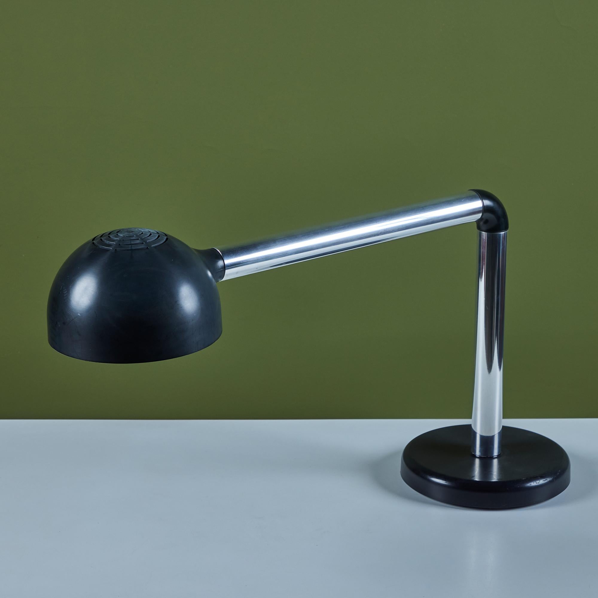 La lampada da tavolo tubolare di Robert Haussmann & Haussmann, 1960 circa, Svizzera, ha un design elegante e minimalista. La lampada presenta un paralume a cupola in plastica nera e uno stelo curvo in alluminio con connettore in plastica nera. La
