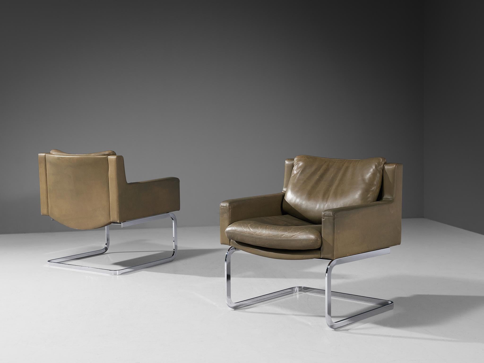 Robert Haussmann for De Sede, pair of armchairs model 'DS-201', chrome-plated metal, leather, Switzerland, designed in 1957 

A design by Robert Haussmann that features a cubic shaped structure. The backrest runs into the armrests by means of a