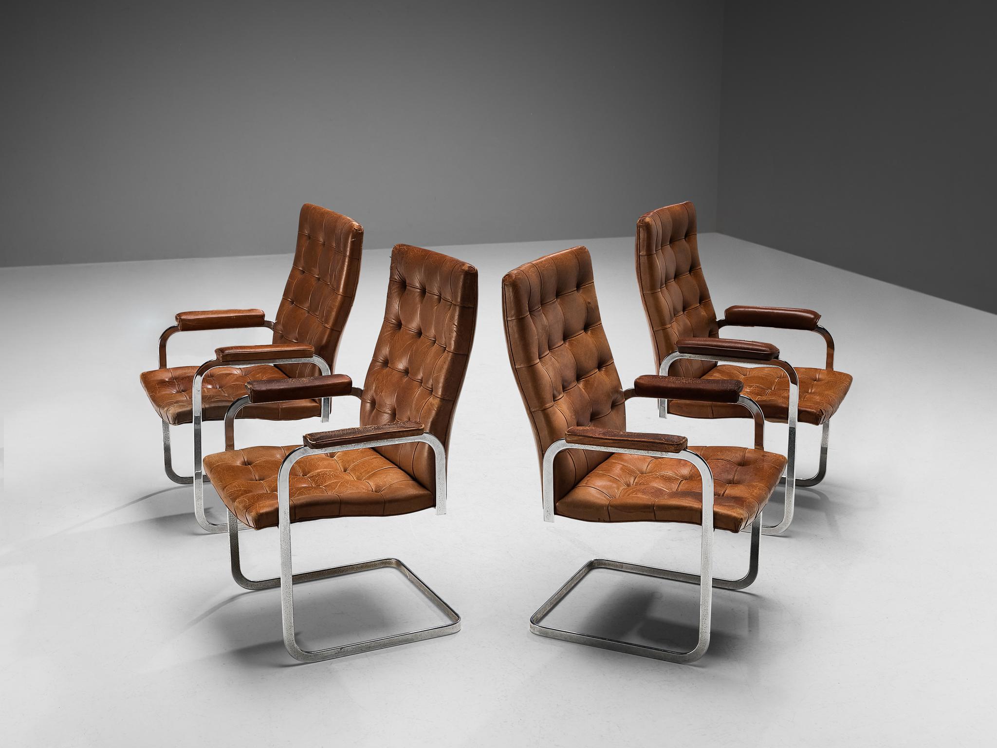 Robert Haussmann for De Sede, set of four dining chairs, model 'RH-304', leather, chrome-plated steel, Switzerland, ca. 1950. 

This cantilevered set of tufted chairs with leather padded armrests is designed by Robert Haussmann for De Sede. The set