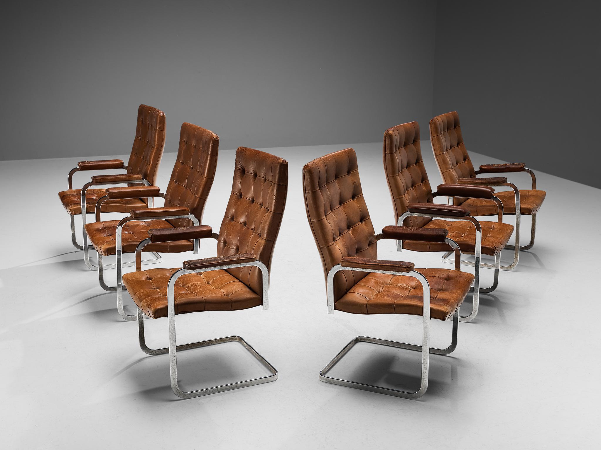 Robert Haussmann for De Sede, set of six dining chairs model 'RH-304', leather and steel, Switzerland, ca. 1950. 

This cantilevered set of tufted chairs with leather padded armrests is designed by Robert Haussmann for De Sede. The set has a