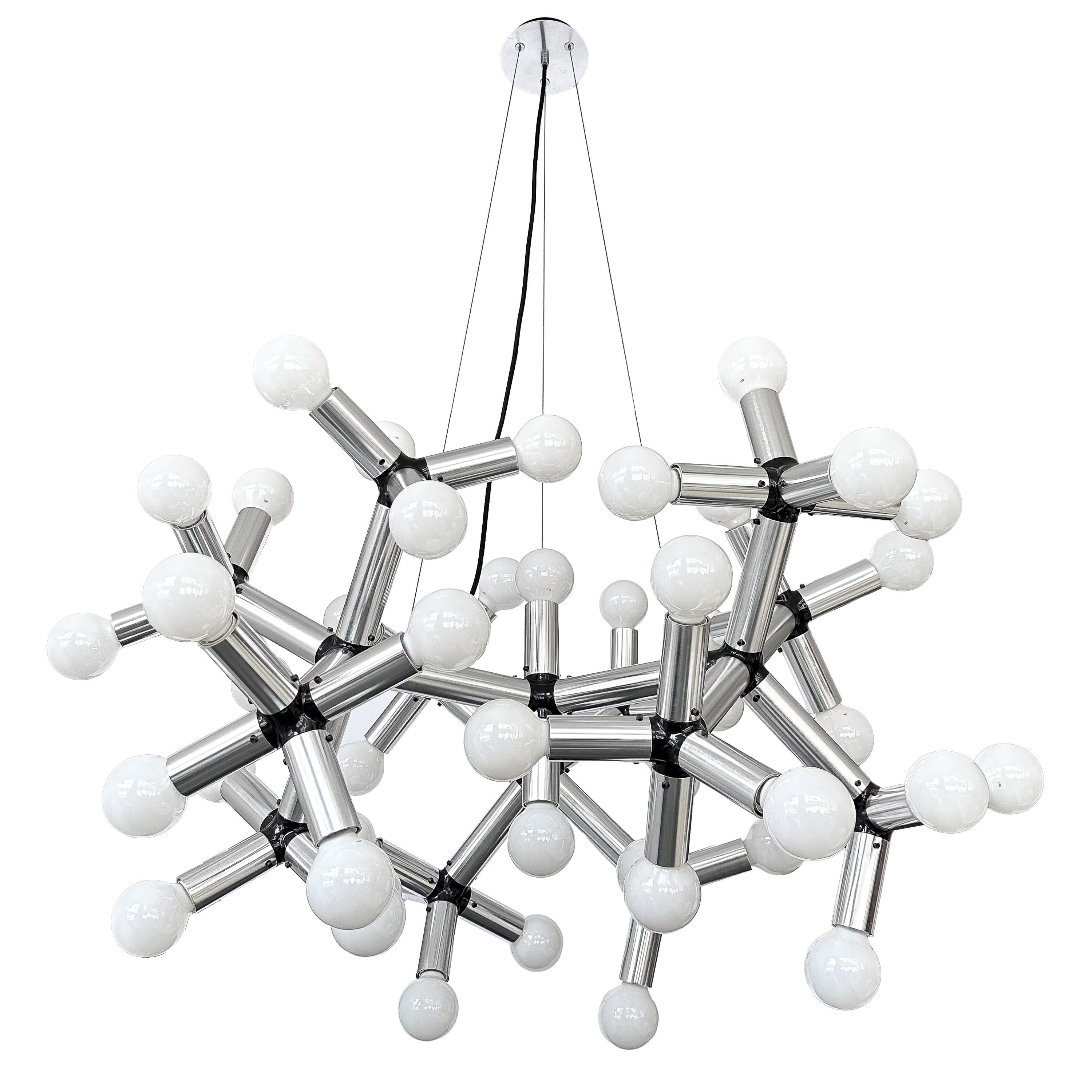 Step into a world where art meets function in the most sublime way with this rare monumental 50 light suspension chandelier by Robert Haussmann, Switzerland circa 1970s. With its distinctive molecular design and commanding presence, this chandelier
