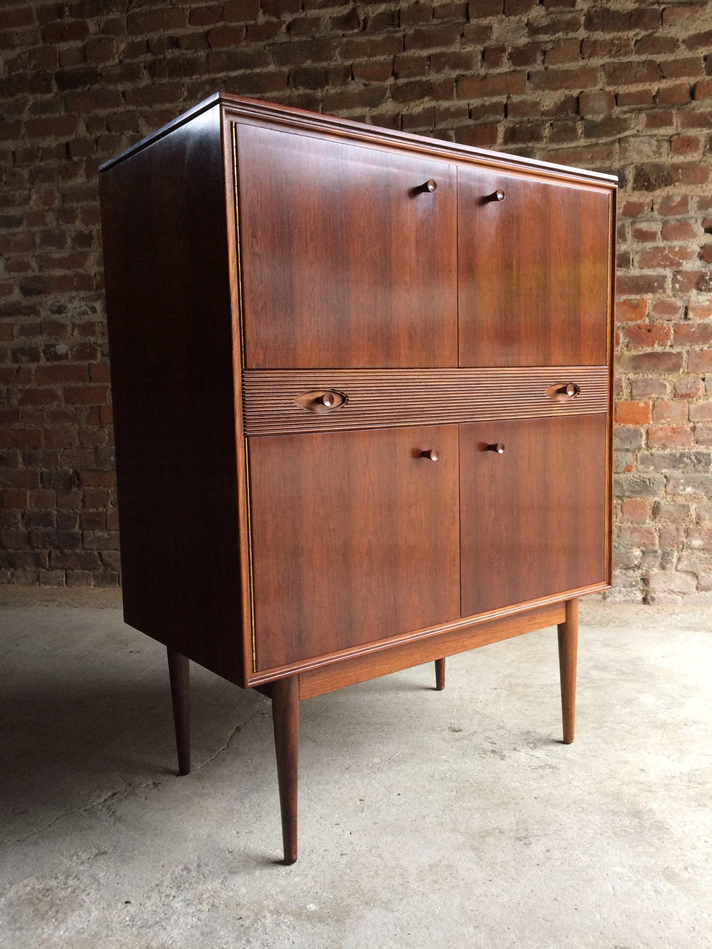 Mid century Hamilton Rosewood Cocktail cabinet designed by Robert Heritage and manufactured by Archie Shine circa 1960, wonderfully styled and beautifully constructed throughout, the double doors to the upper part opening to reveal a formica